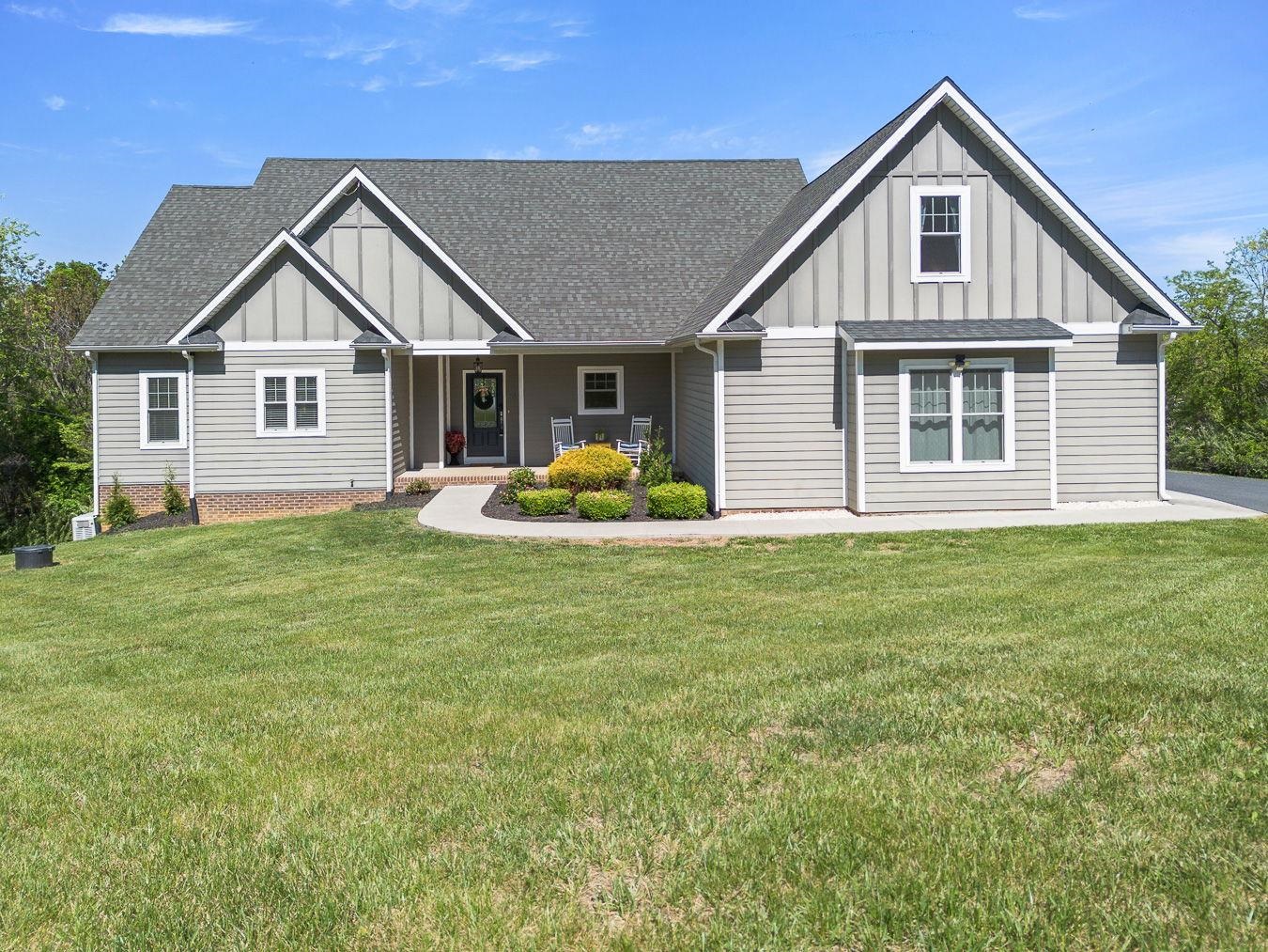 Manicured Landscaping, Hardiboard Siding and Concrete walkway to Paved Driveway