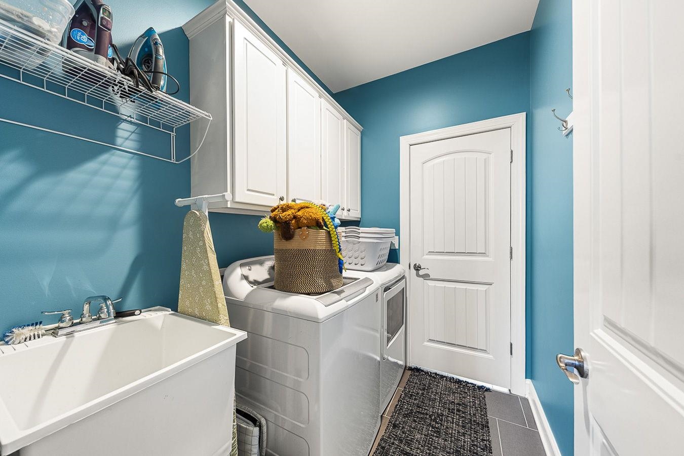 Main Level Laundry Room with Sink and Cabinetry Connected to Master and Living Room