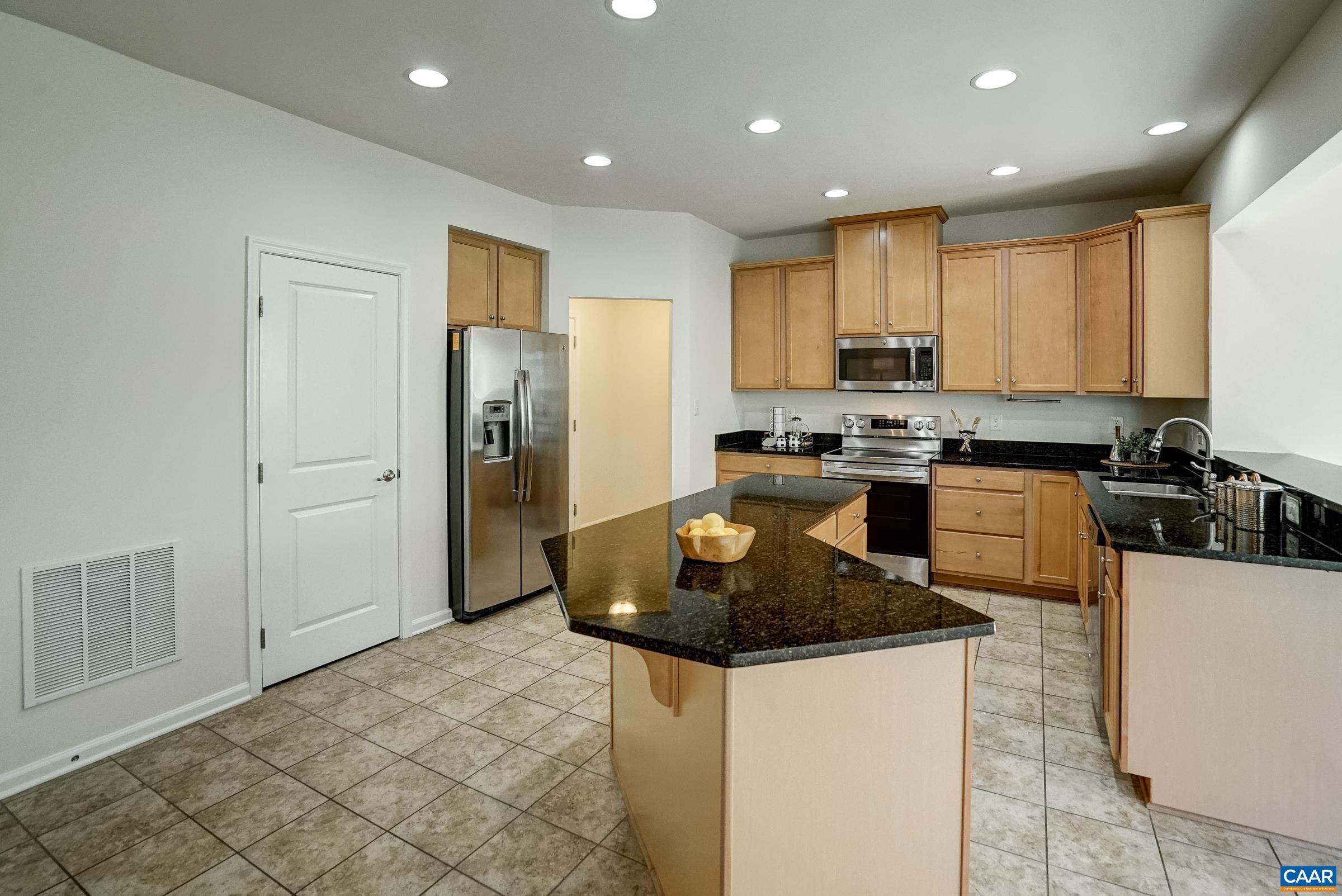 Spacious kitchen with maple cabinets and granite countertops.
