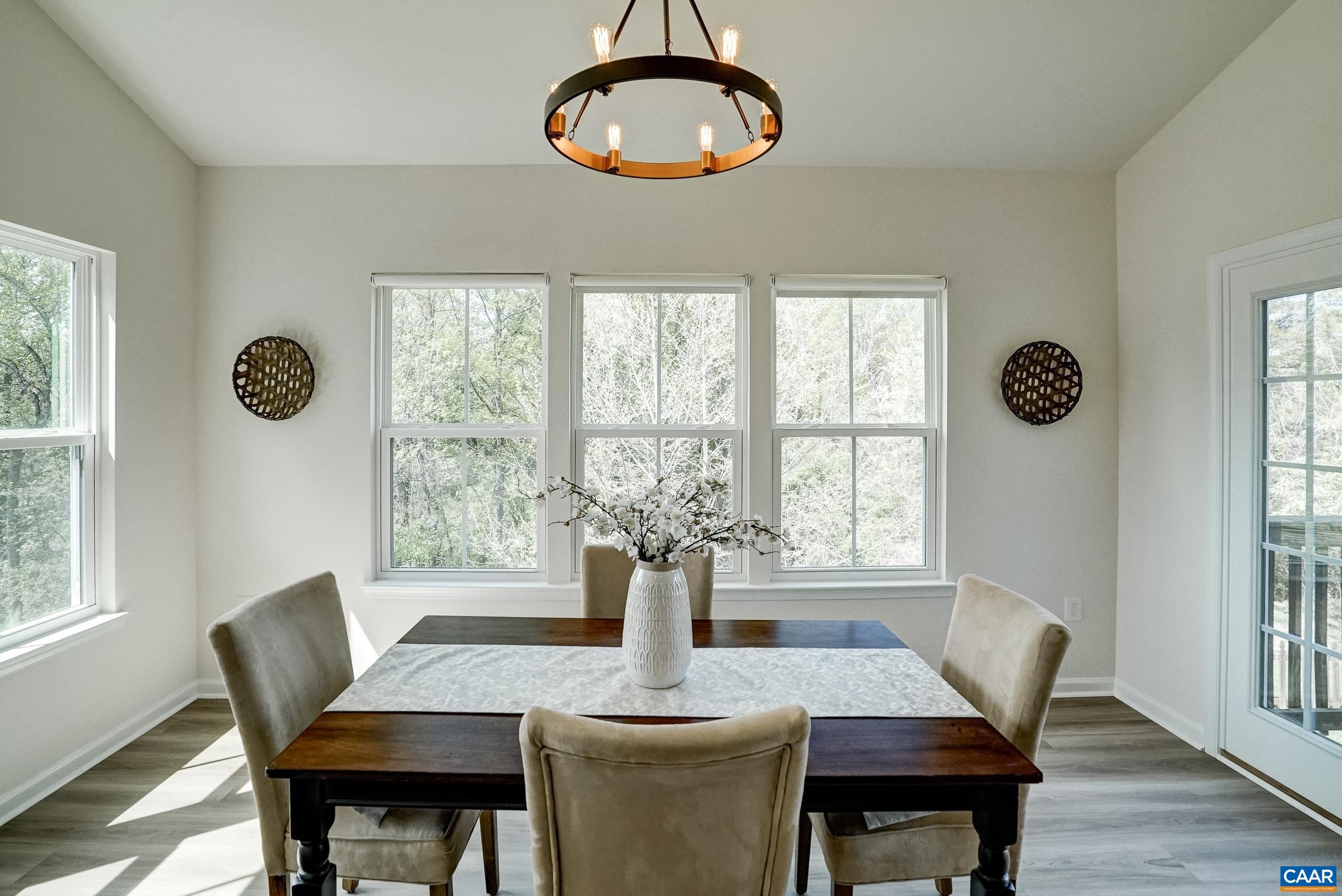 Vaulted dining area with new LVP flooring and modern farmhouse light fixture.
