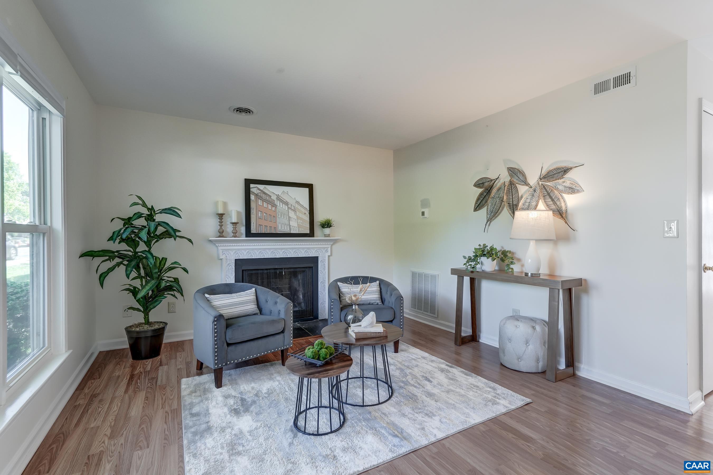 Large light-filled living room at the front of the home features a wood burning fireplace.