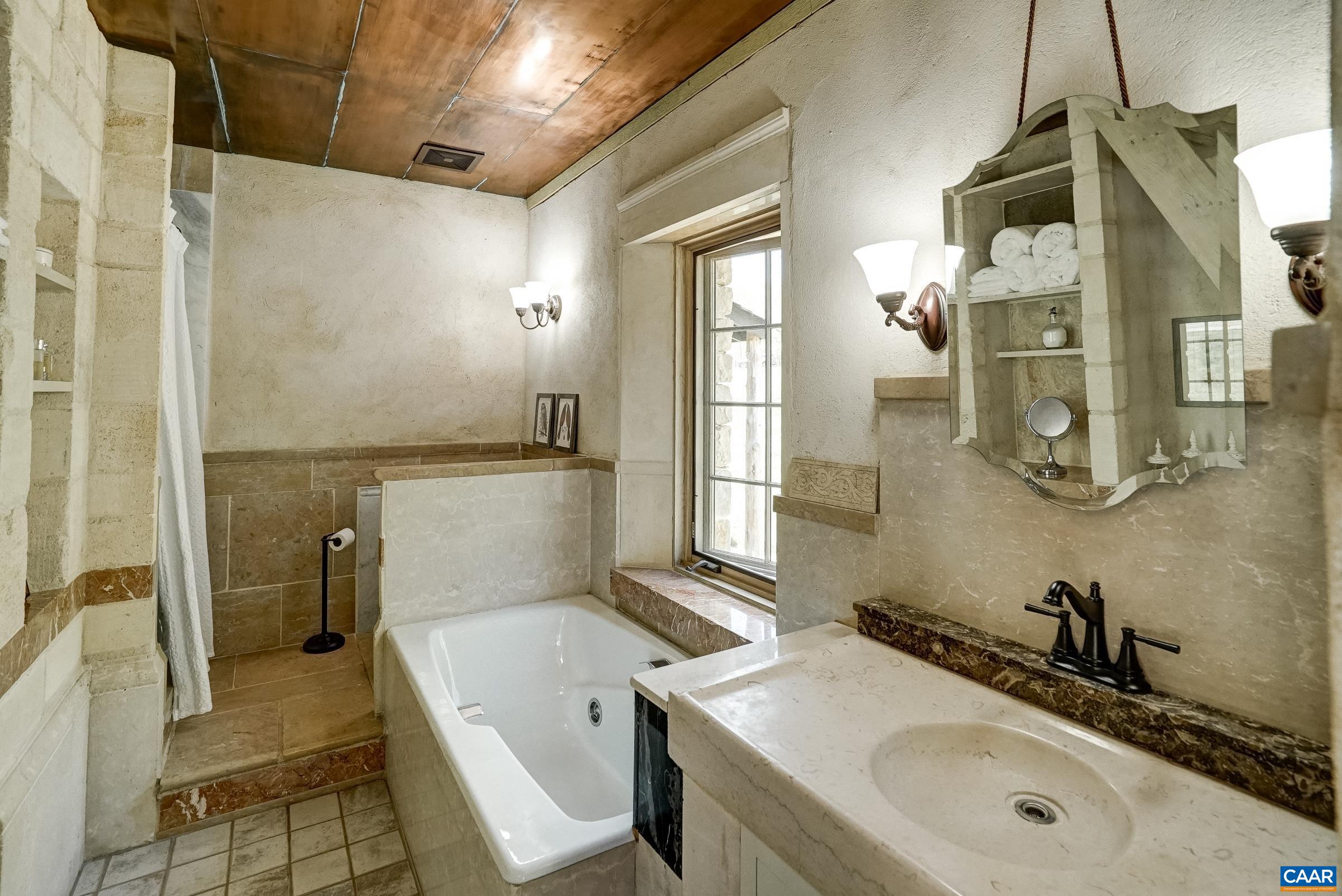 Beautiful soaking tub, carved marble sink and so much more in this spa-like escape!