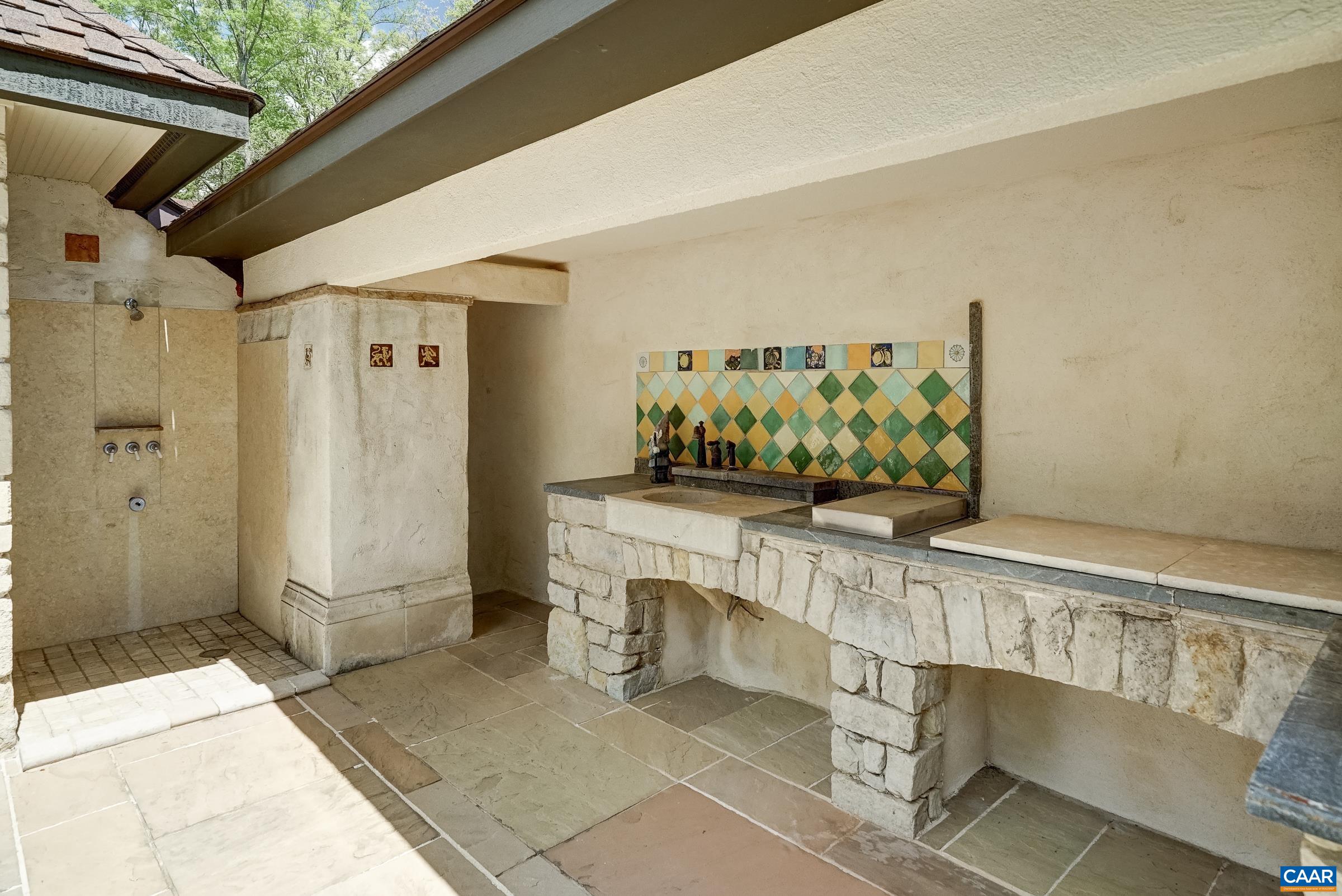 Covered outdoor kitchen area with gas grill, and shower.