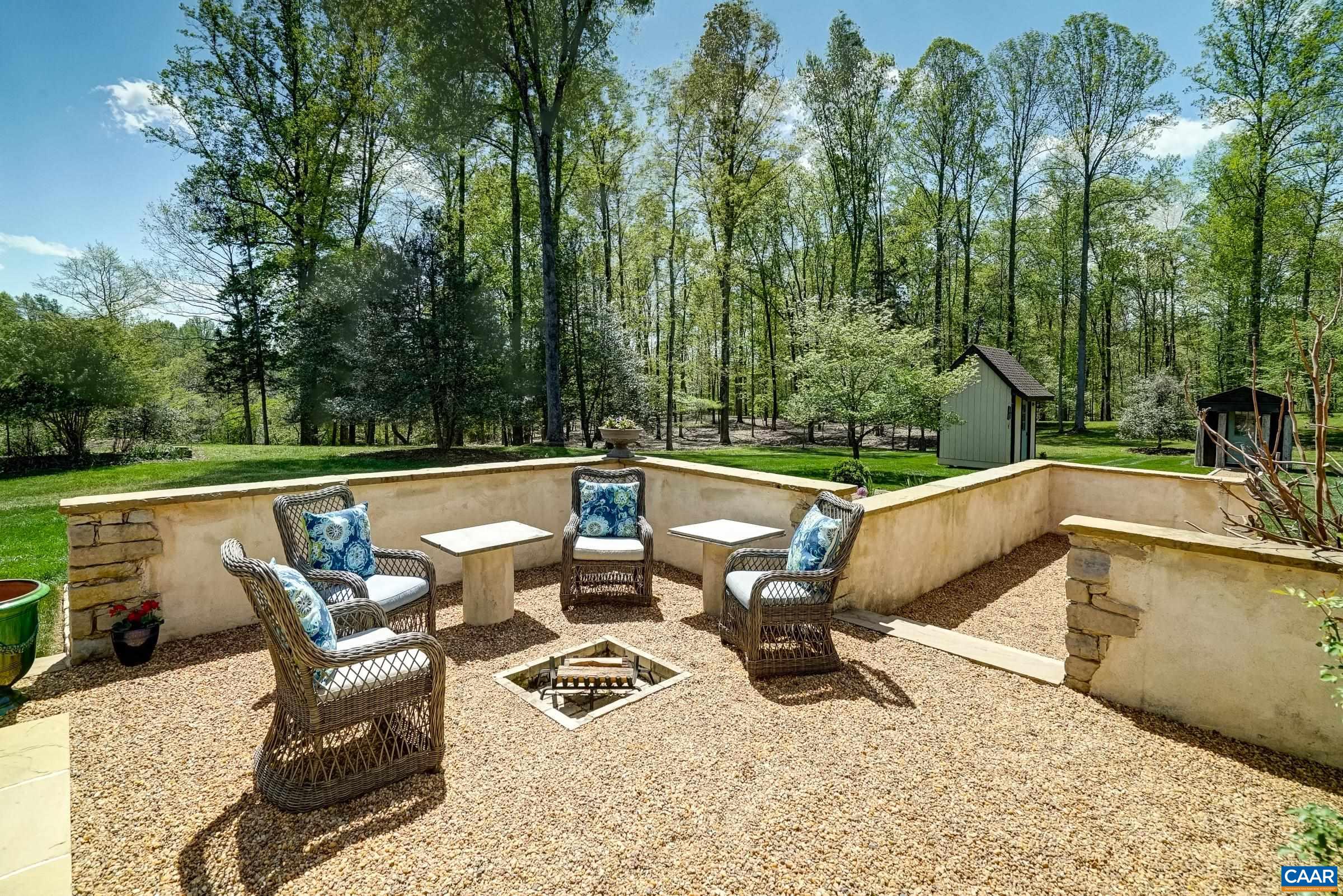 Stone patio with firepit and covered loggia with outdoor kitchen area.