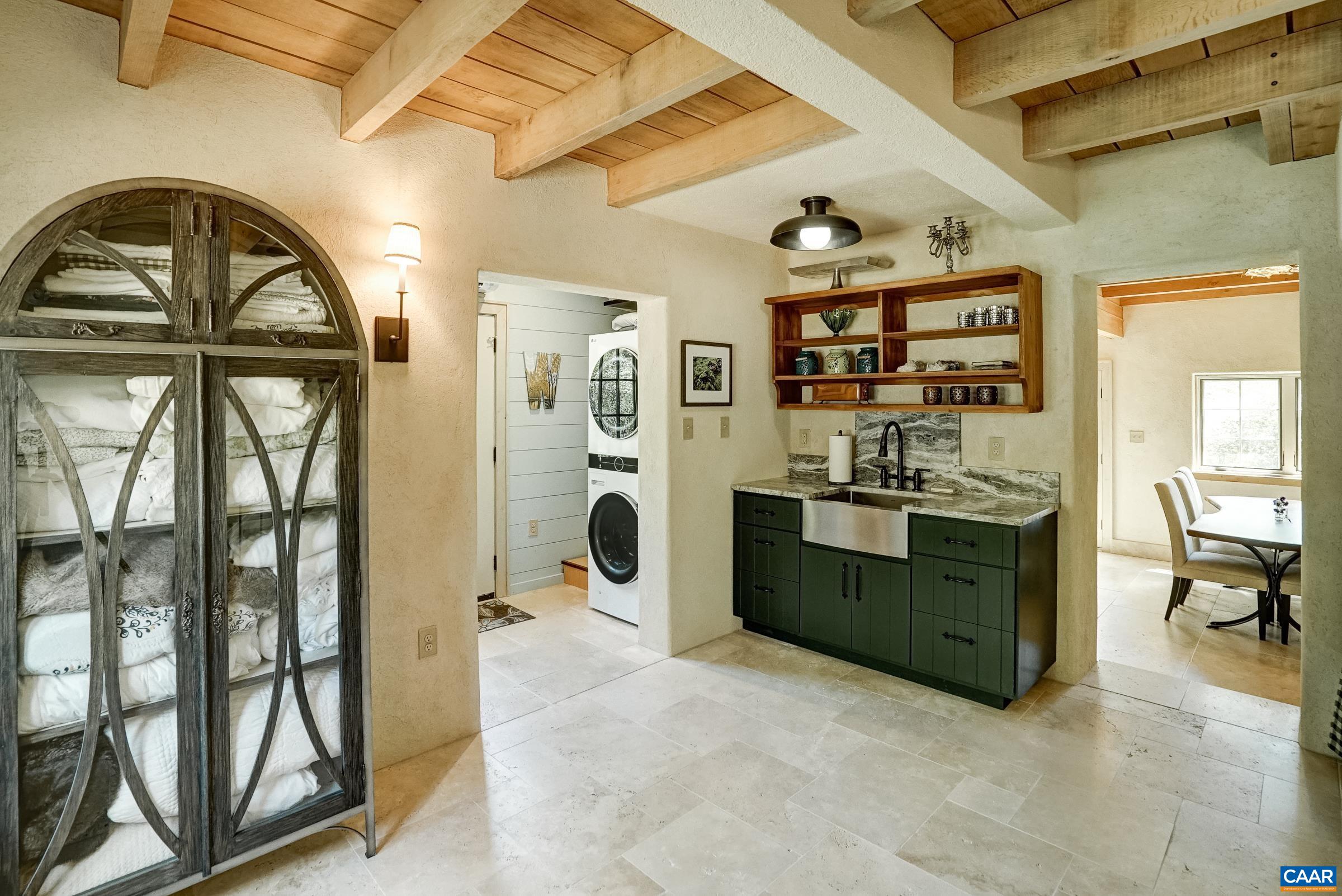 Open kitchenette area features storage, a farmhouse sink and open shelving above.