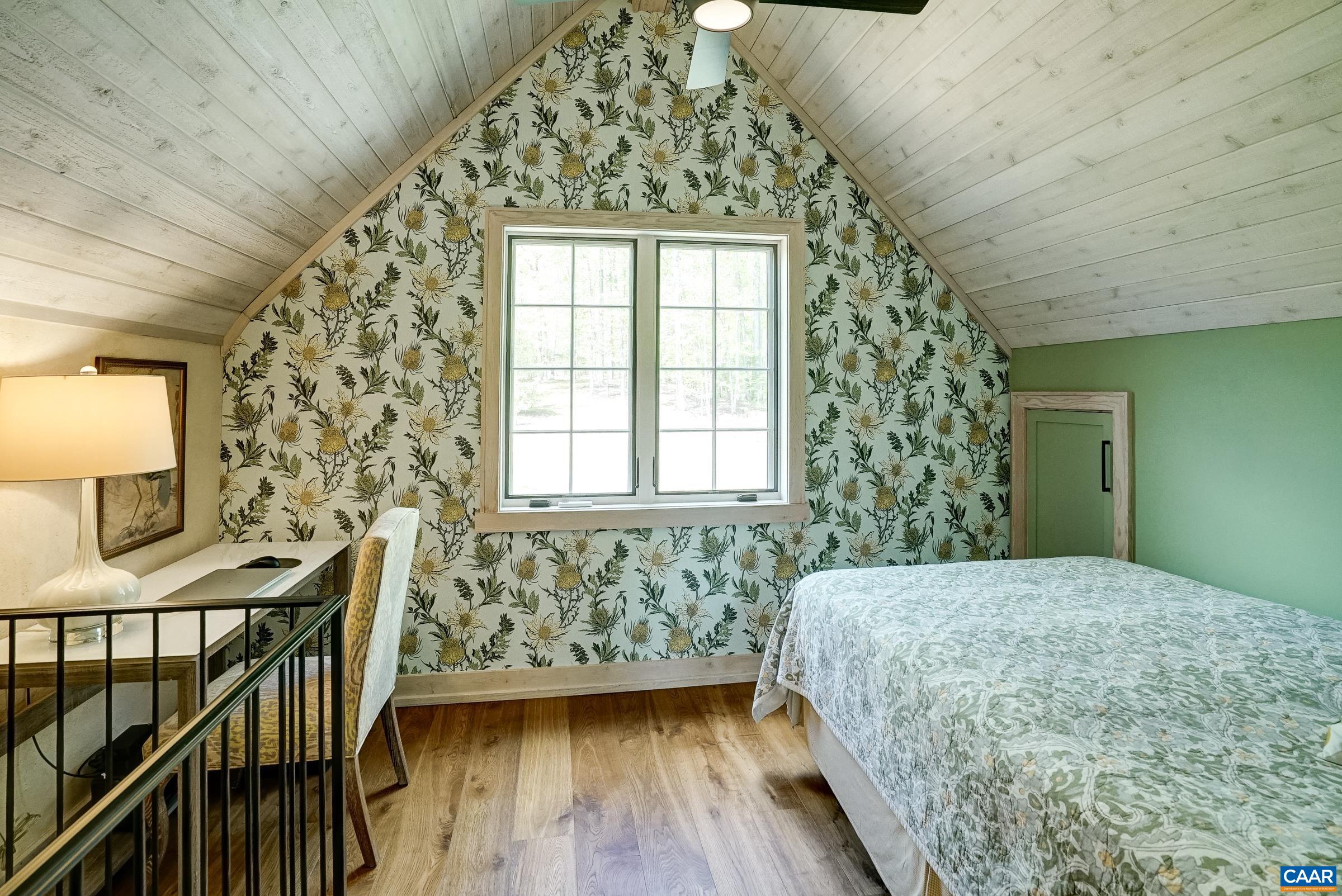 Loft with whitewashed tongue and groove ceiling, and mini split.
