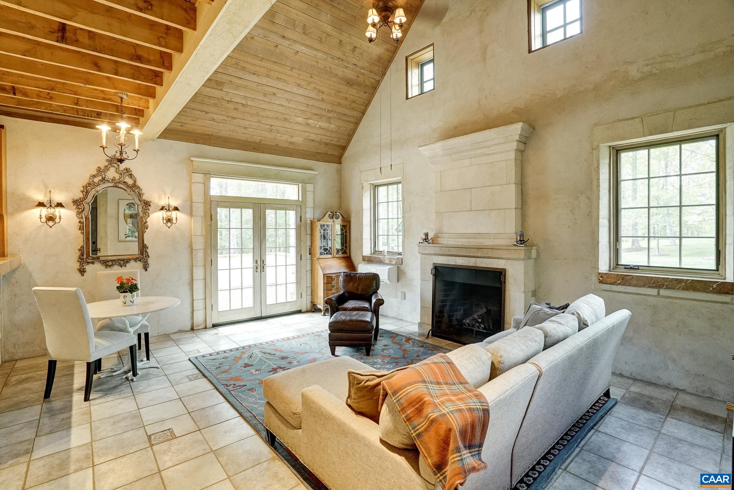 Great room with cathedral ceiling and stunning limestone woodburning fireplace.