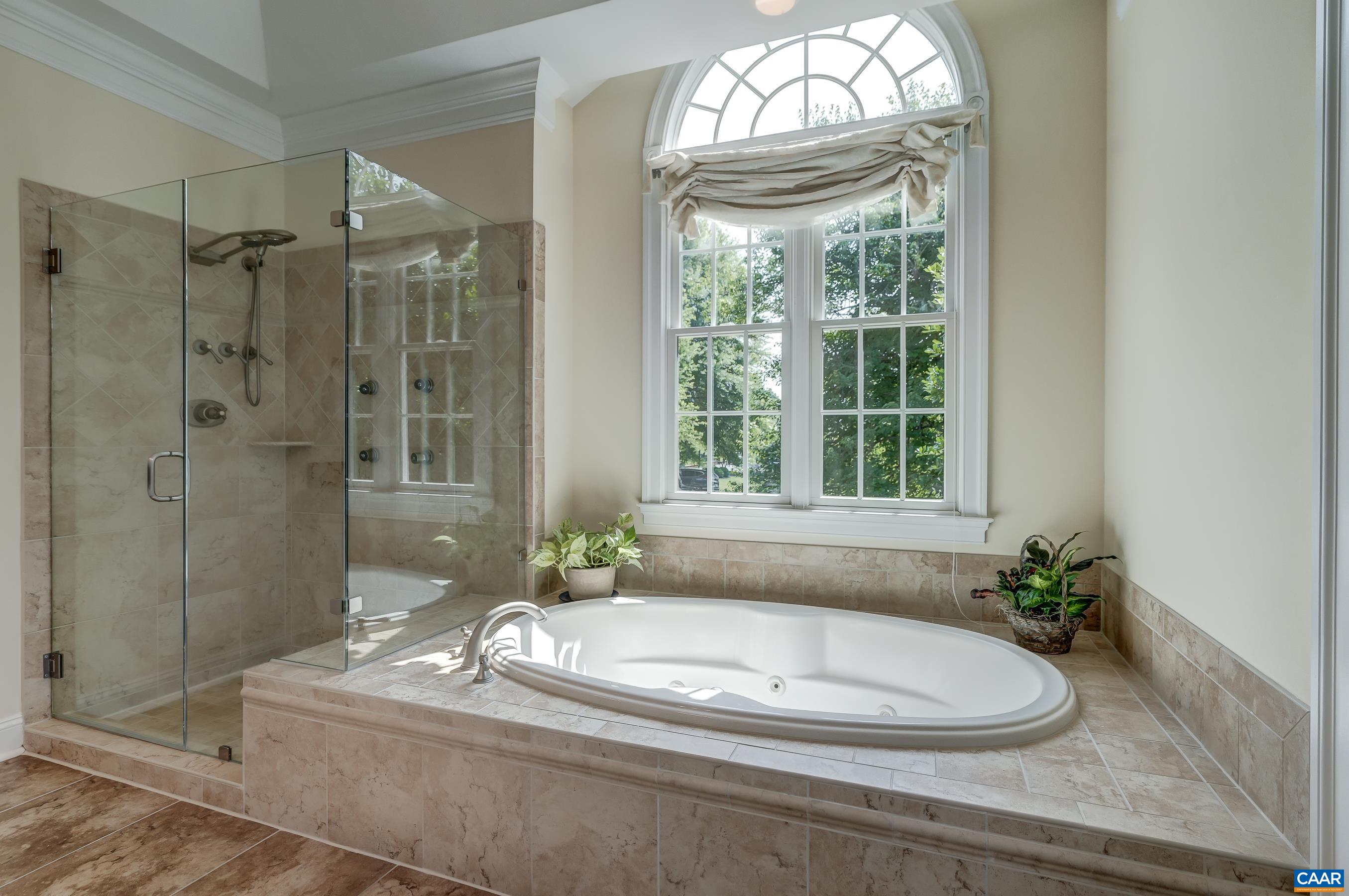 Main level primary bathroom with jacuzzzi soaking tub and shower.