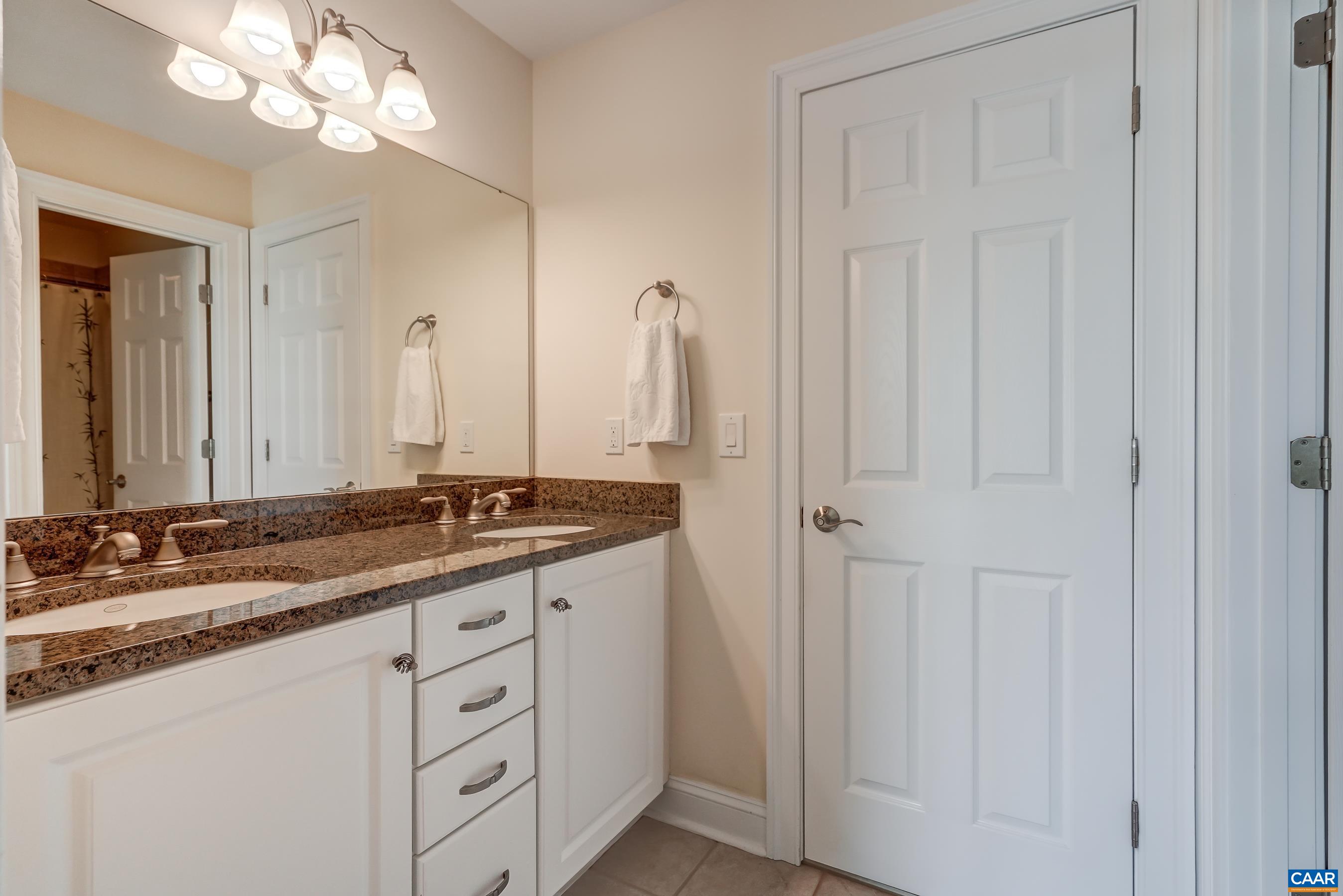 Full bathroom with double sink vanity connects to hall and bedroom 4