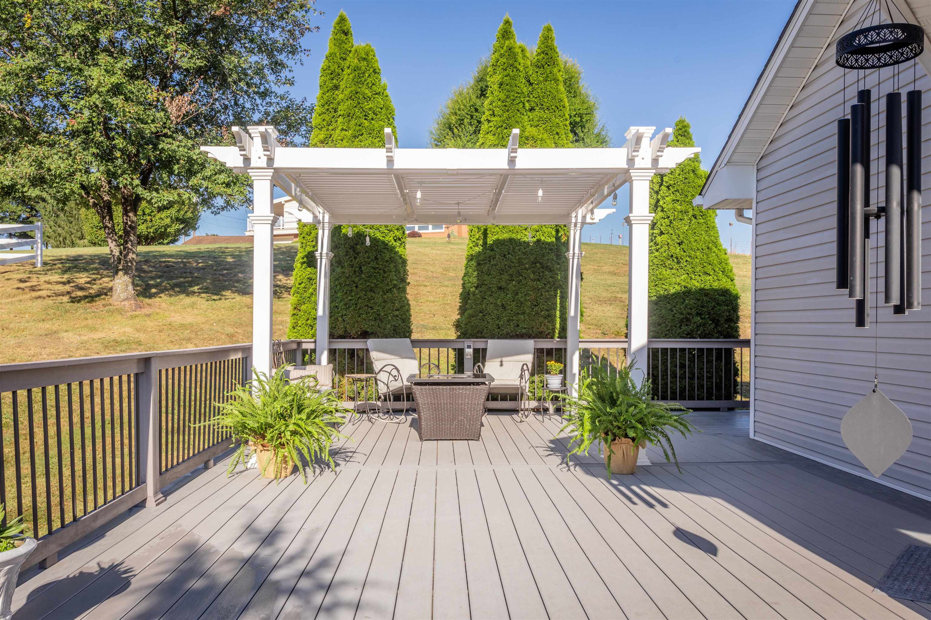 Extensive wrap around composite decking with perimeter benches and a pergola.
