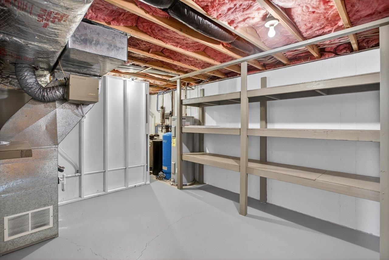 Utility room with an abundance of shelved storage, water softener system with UV light and an installed radon gas system. New up pump installed 2025 for 1/2 bath.