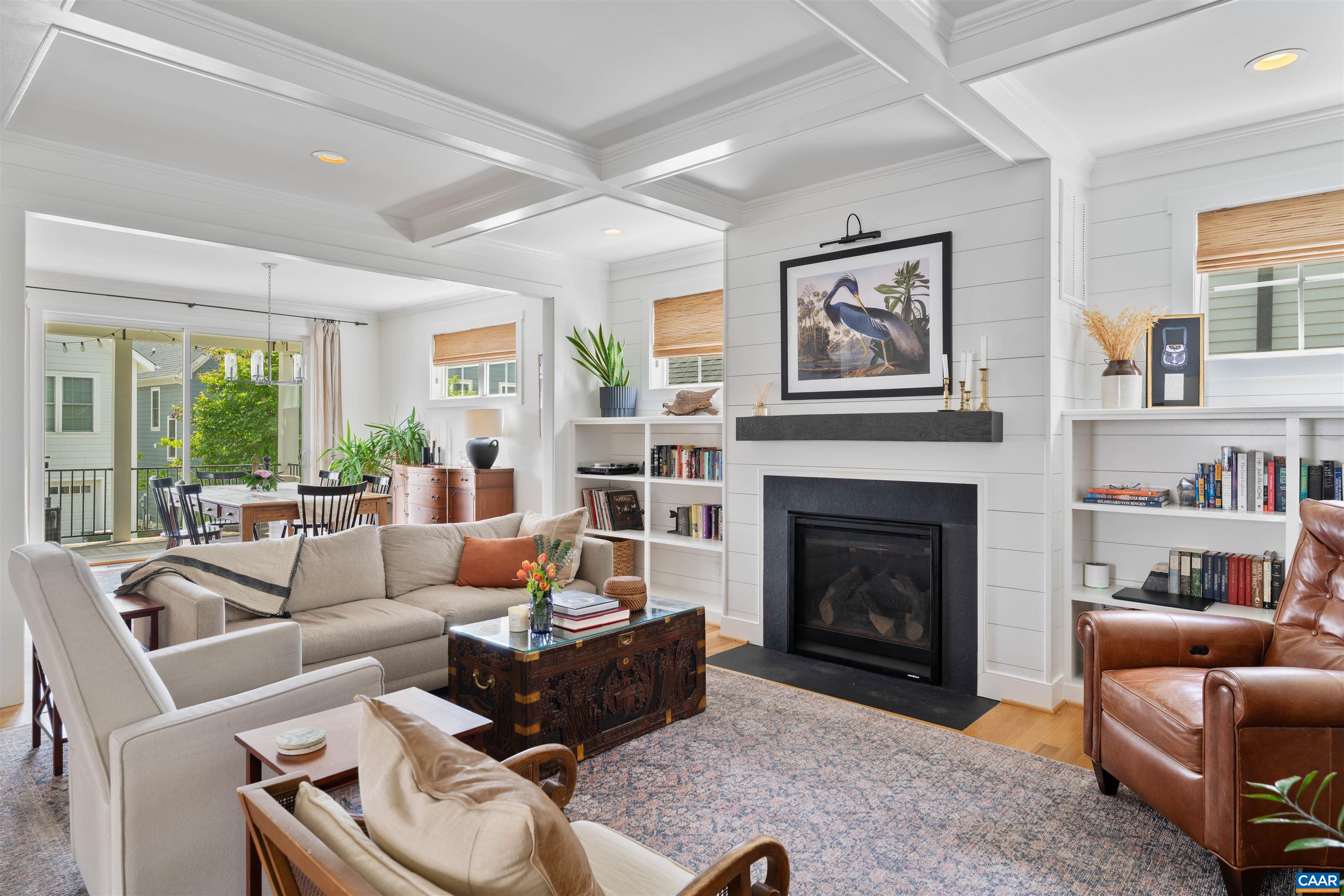 Attractive living room with coffered ceiling, gas fire place and built in book shelves!