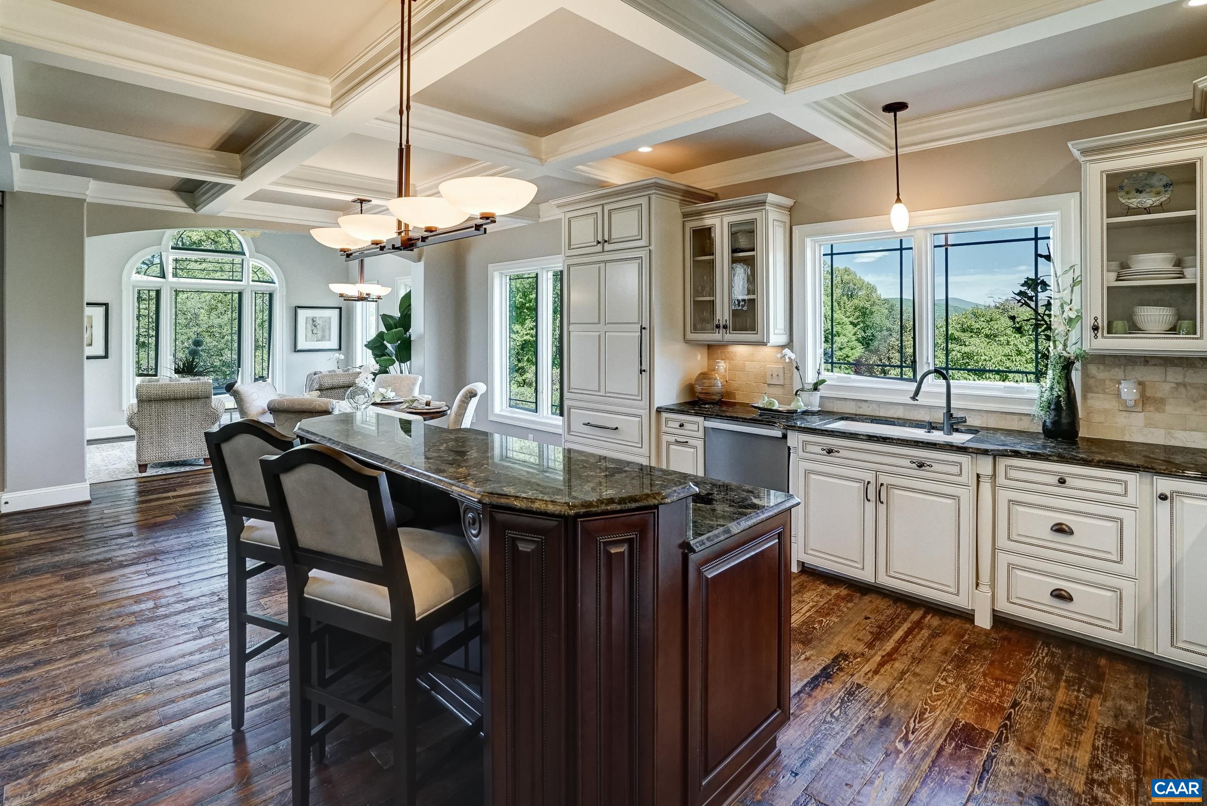 Gourmet kitchen features coffered ceiling, granite counters and ivory glazed custom cabinets.