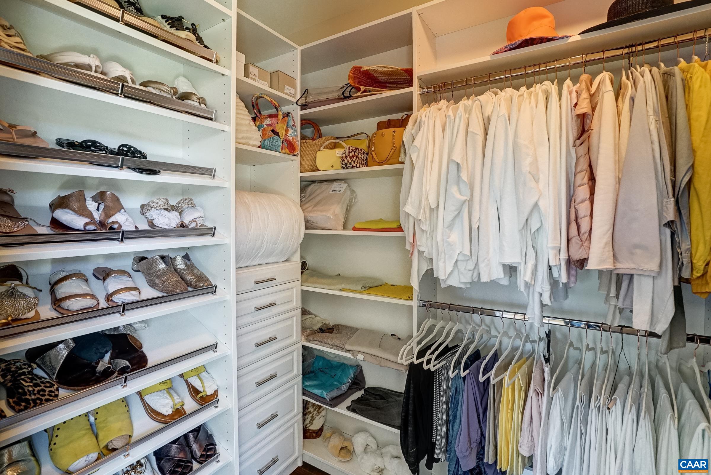 Walk in closet with custom shelving and storage.