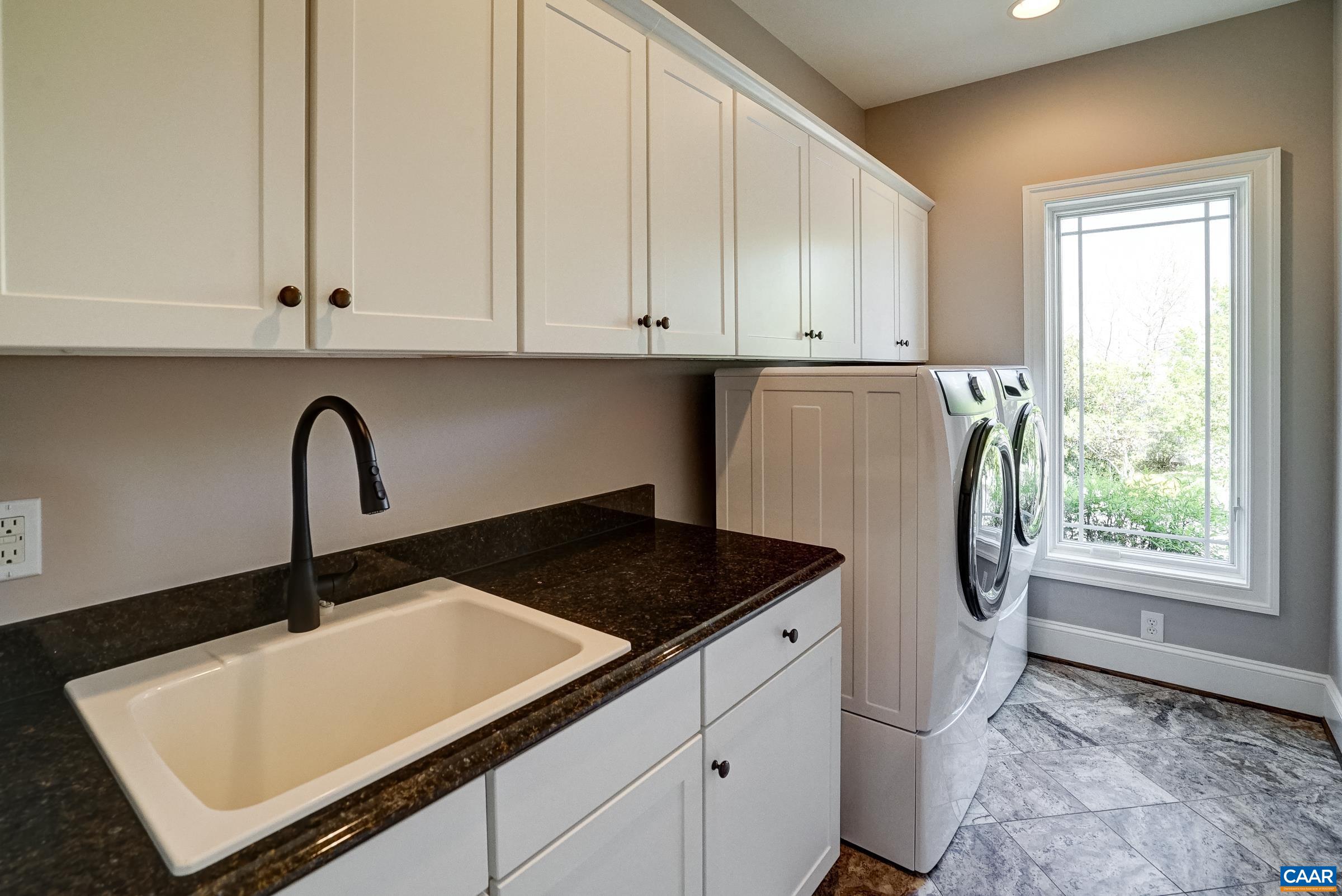 Large laundry room with storage and utility sink.