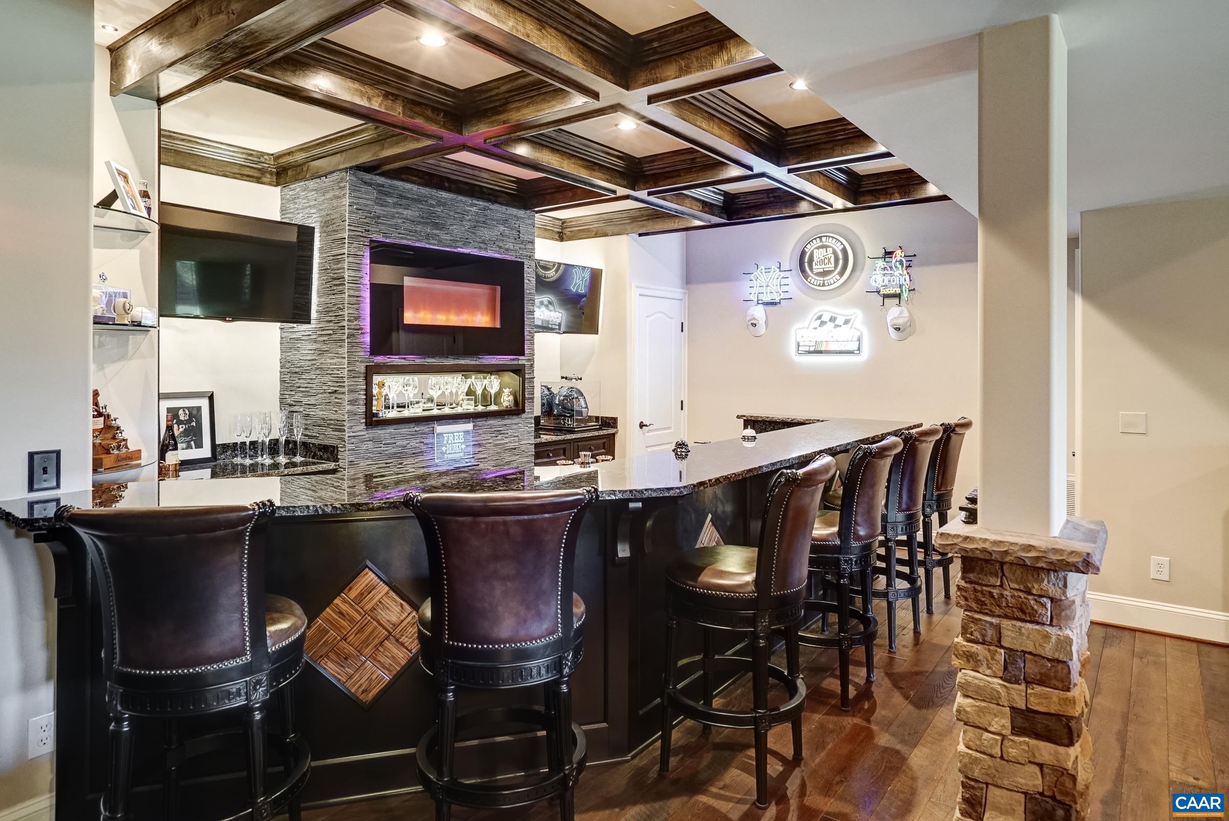 Stunning full bar with raw edge granite, maple coffered ceiling, and wine/beer fridge.