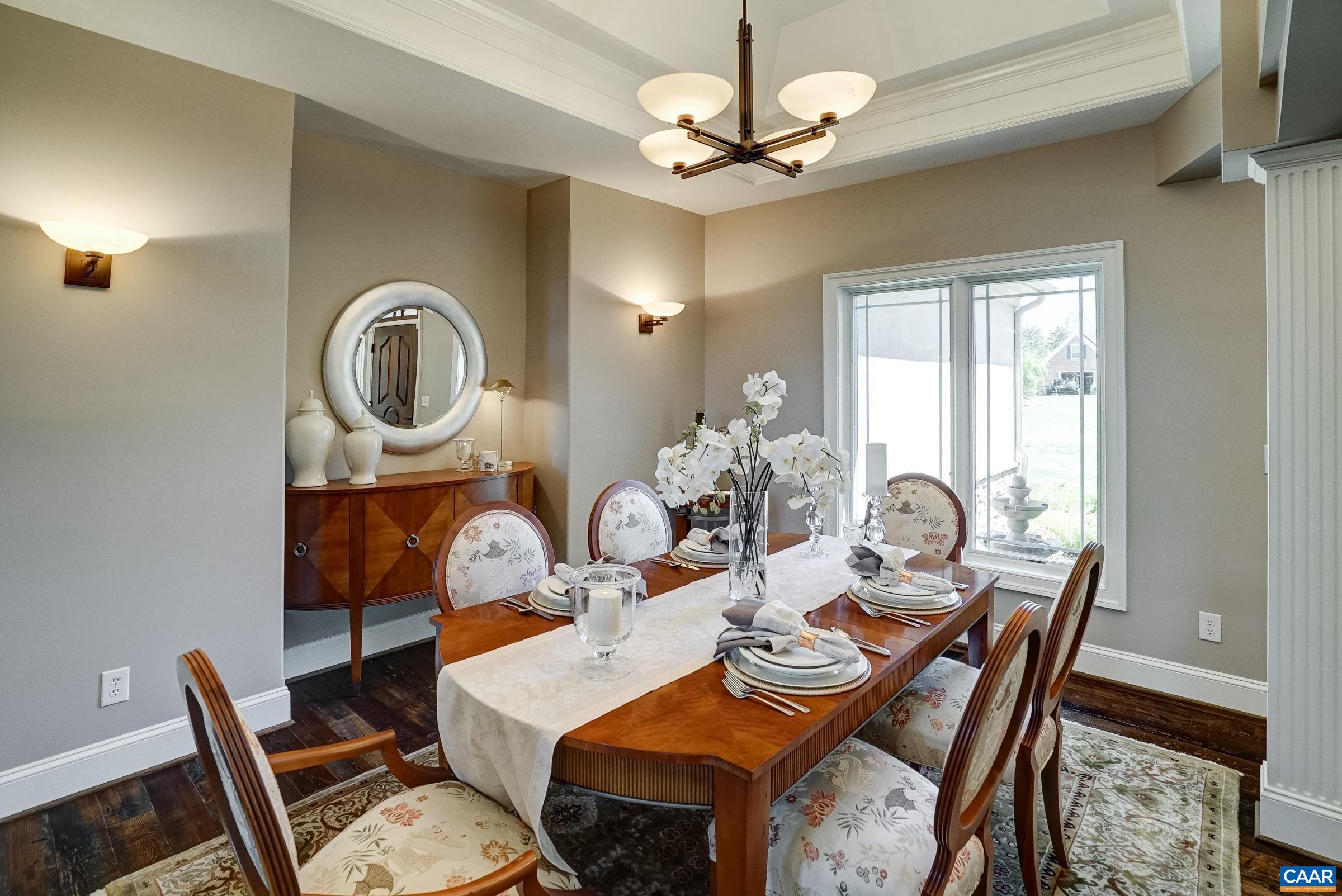 Formal dining room features tray ceiling buffet nook, and formal columns.