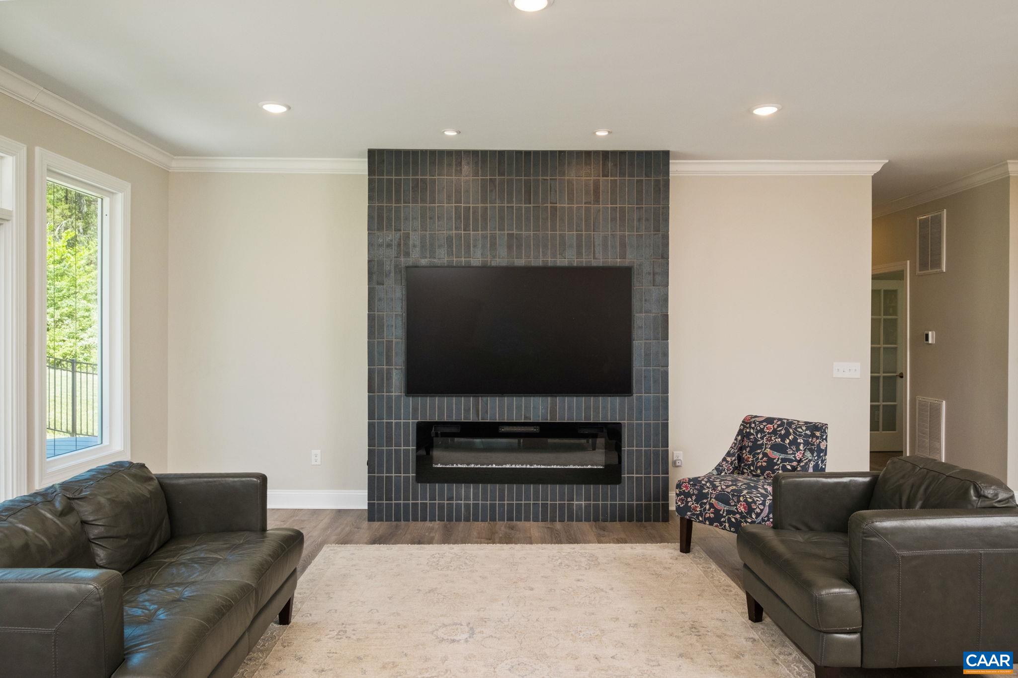 The custom built fireplace surround is brick, and fireplace is electric.
