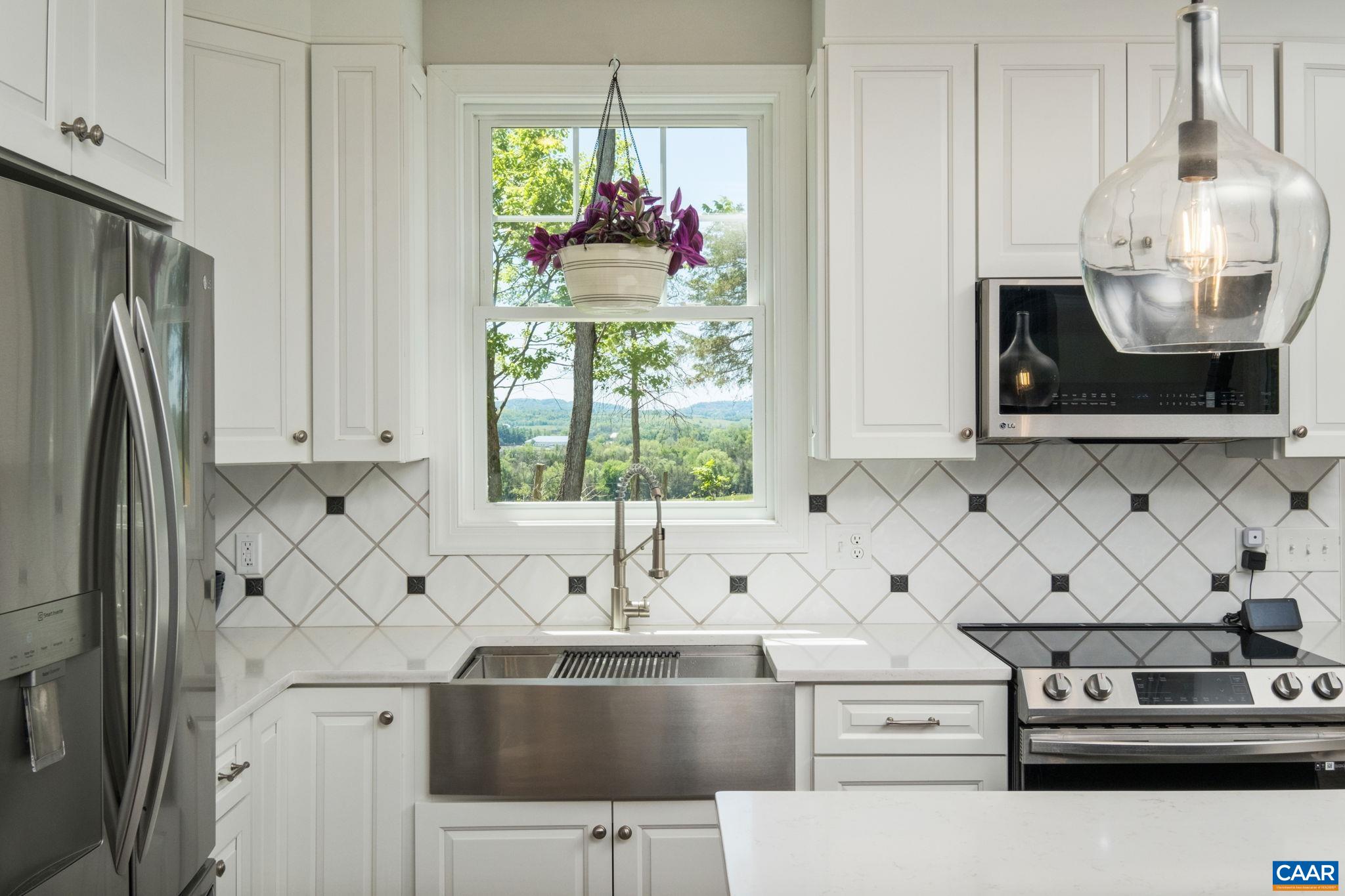 It may look like a painting, but that is the gorgeous view from the kitchen sink.  Also in view are tile backsplash, quartz countertops, and farmhouse sink.
