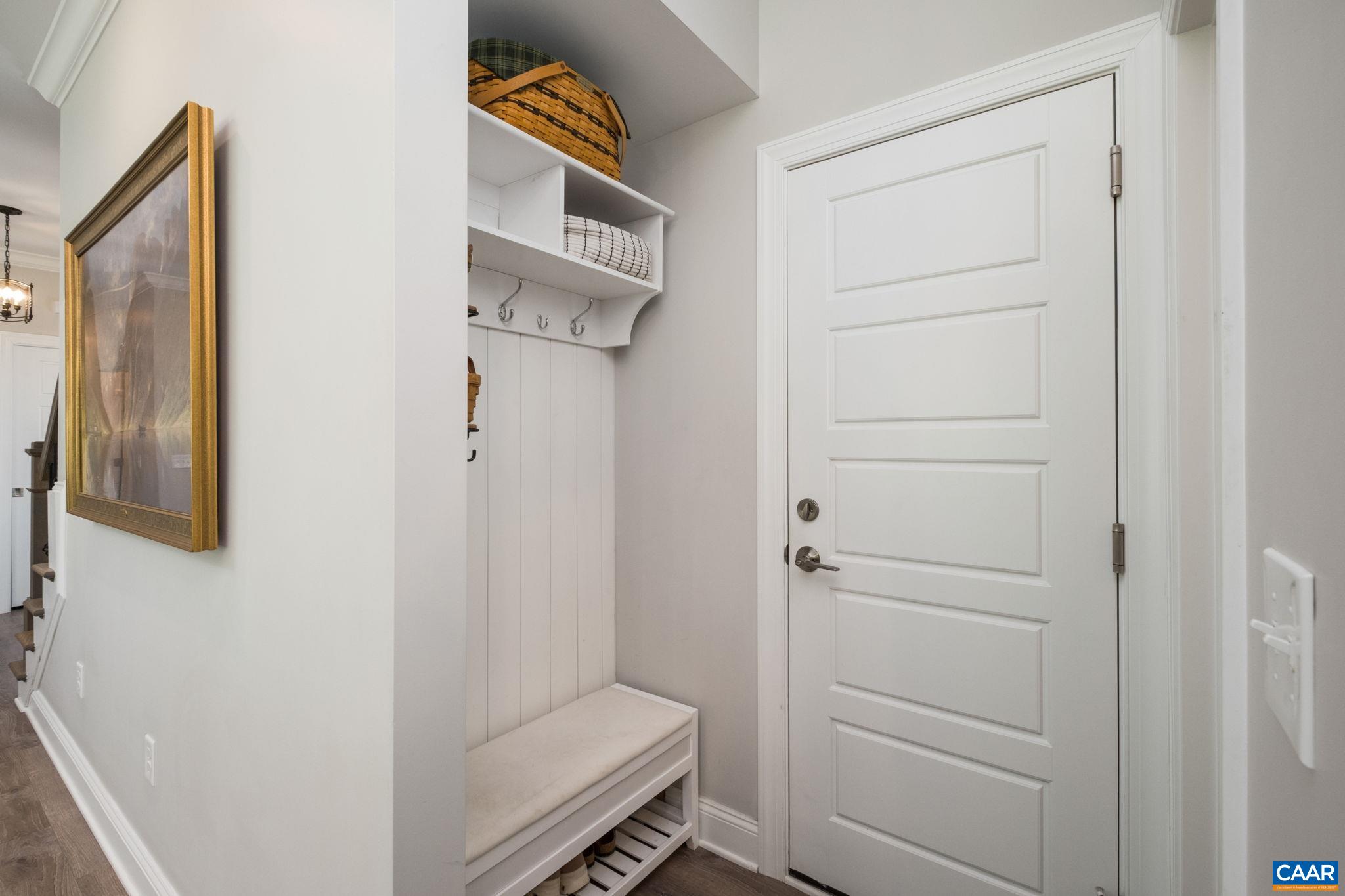 In view is the welcome center, located just off the garage and kitchen. Across from the welcome center you will find the walk-in pantry (walk-in pantry is not in camera view). The door to the garage is in view, and to the right of the welcome center.