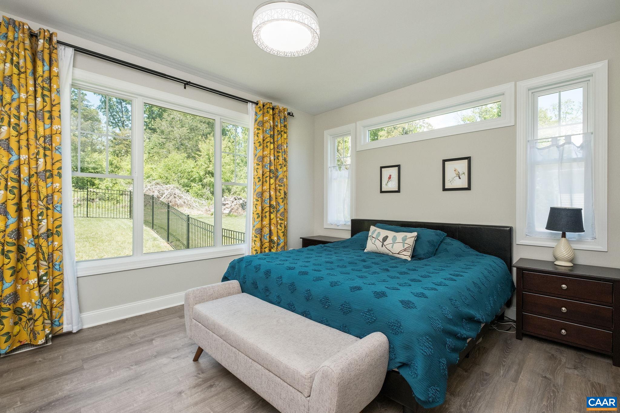 The primary bedroom is located on the main level, at the back of the hallway, with its own hallway.  The showcase windows continue in this room so you can enjoy the outdoor views.