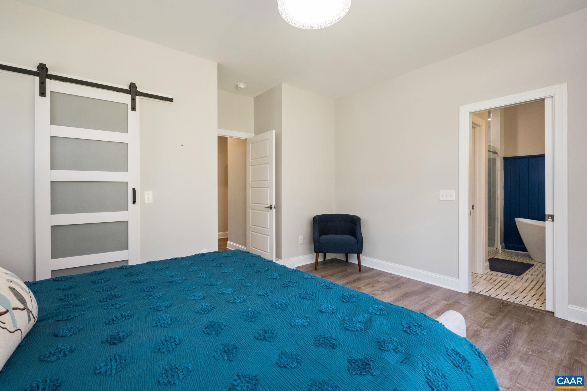 The walk-in closet features a barn door.  The primary bedroom is sizable, and features a small sitting area near the bathroom.
