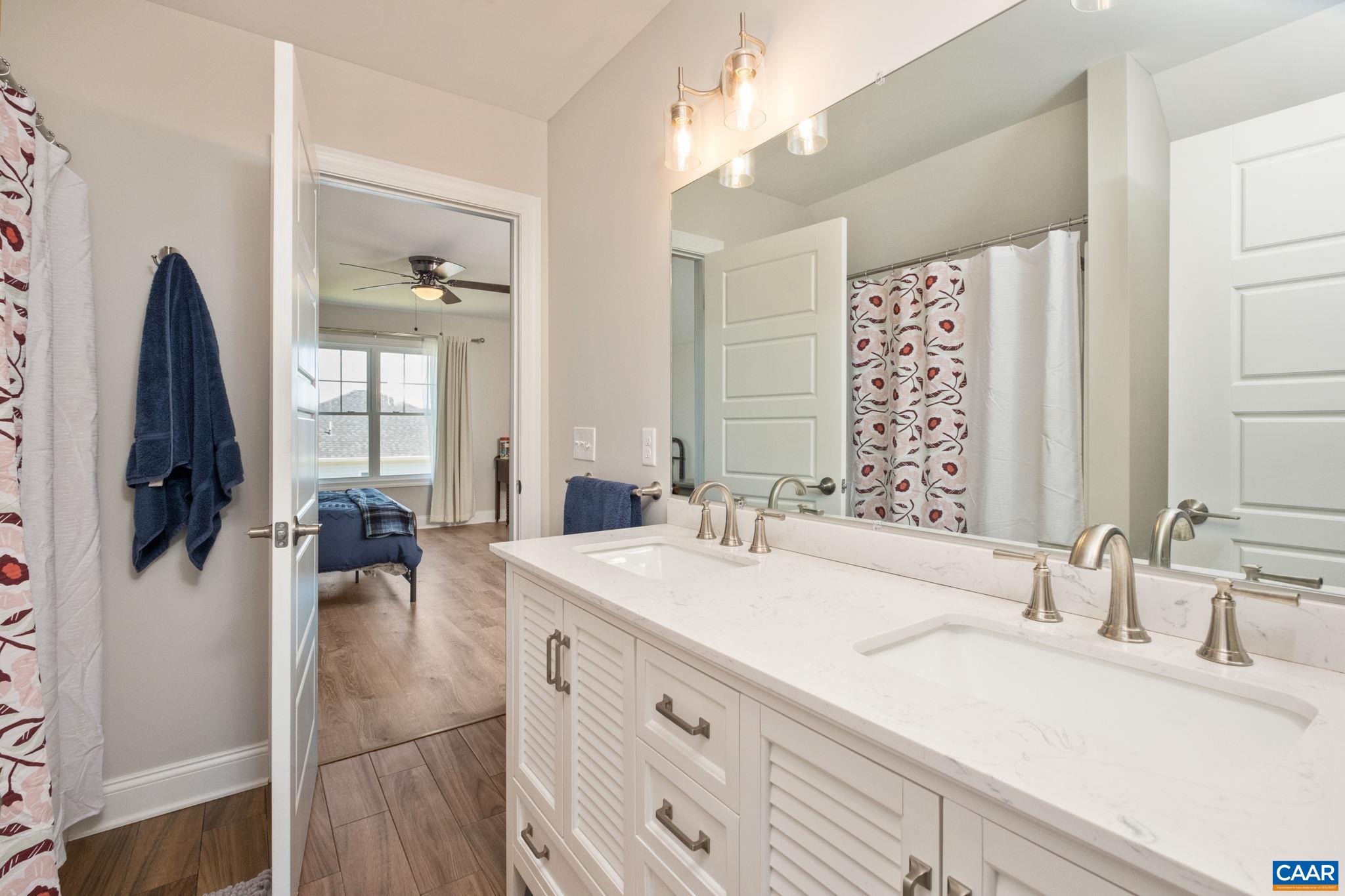 The 3rd bathroom, shared by bedroom 4 and the bonus room, features dual vanities.