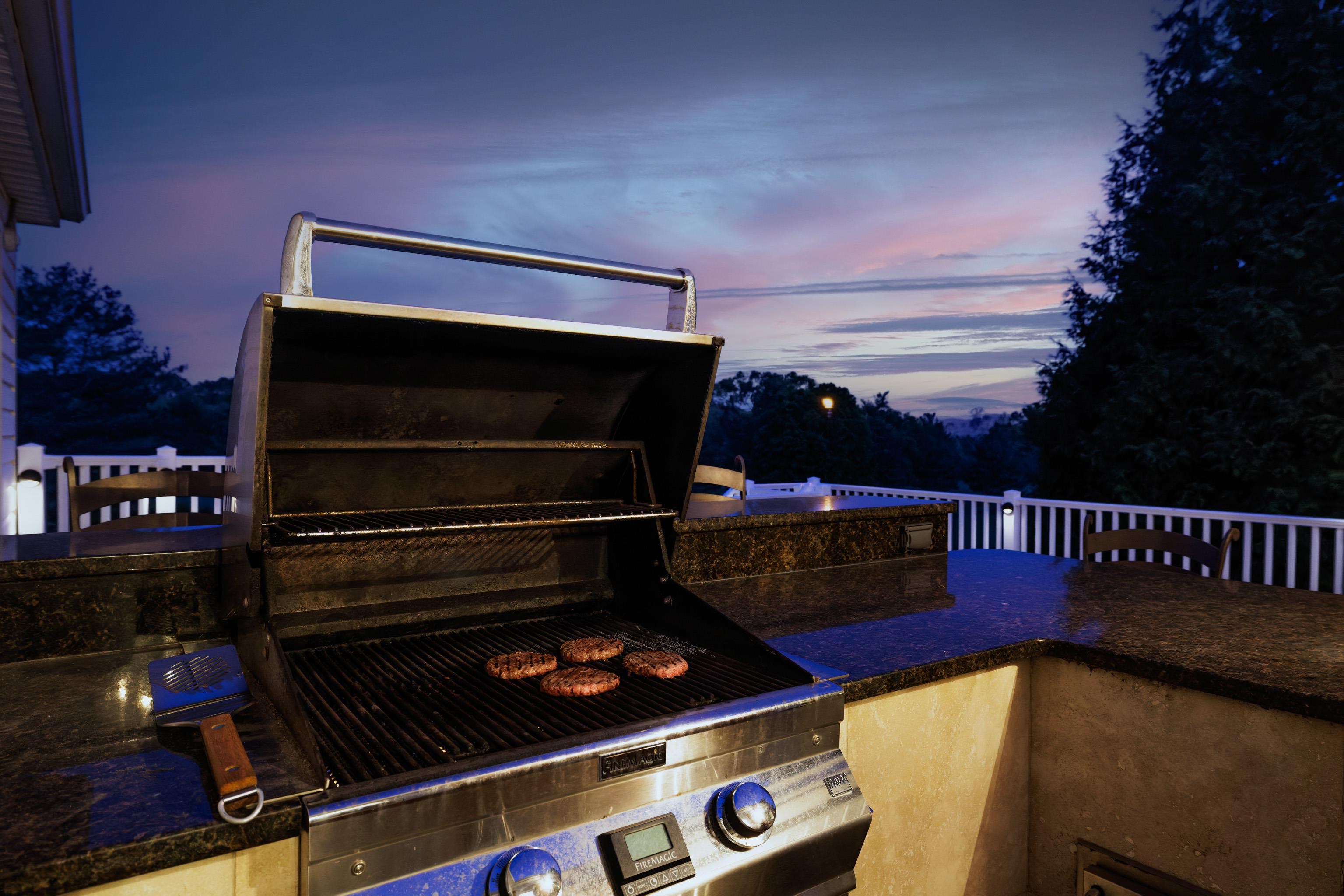 Burgers on the grill looking over the golf course at sunset.