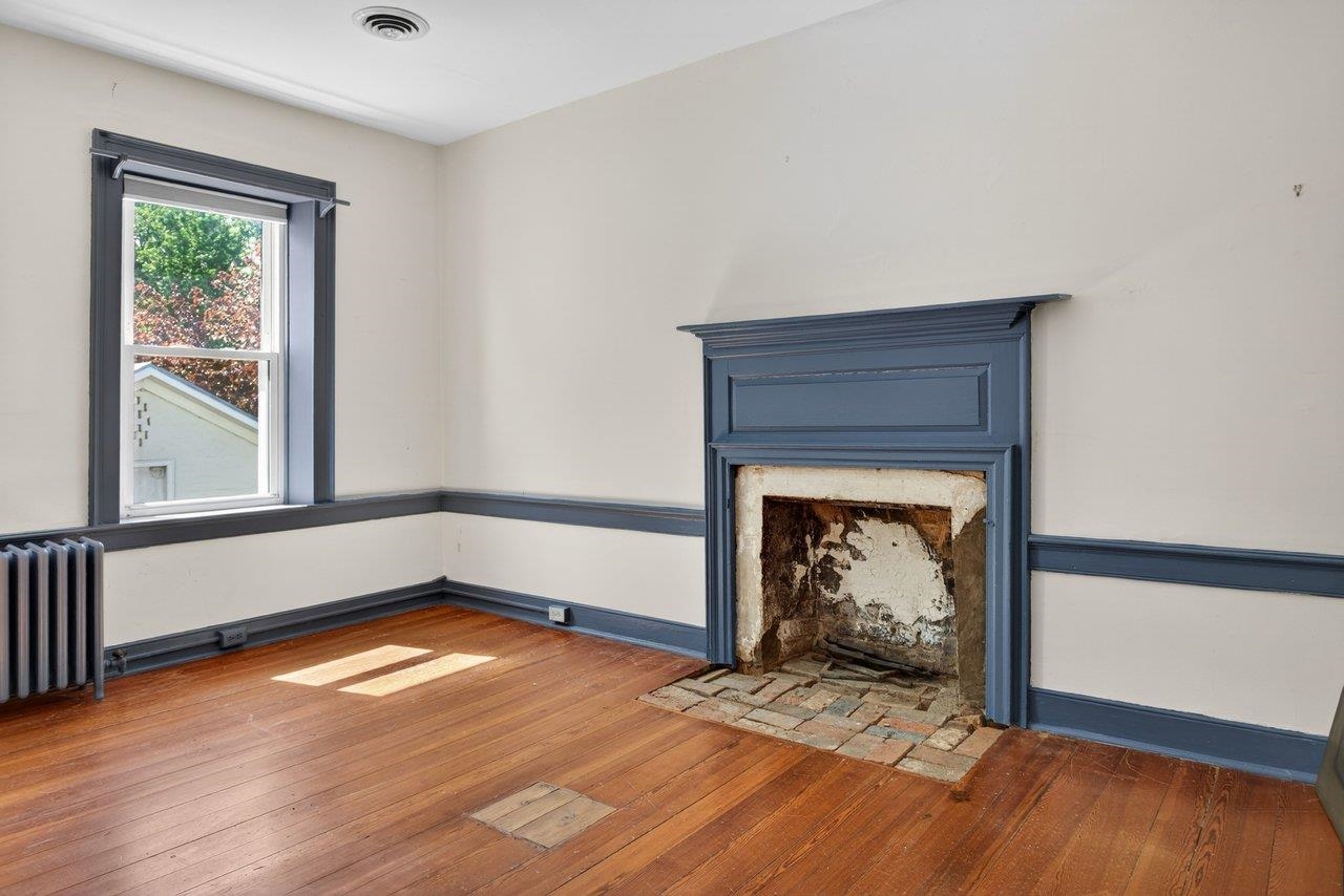 This large bedroom also has a fireplace and hardwood floors.