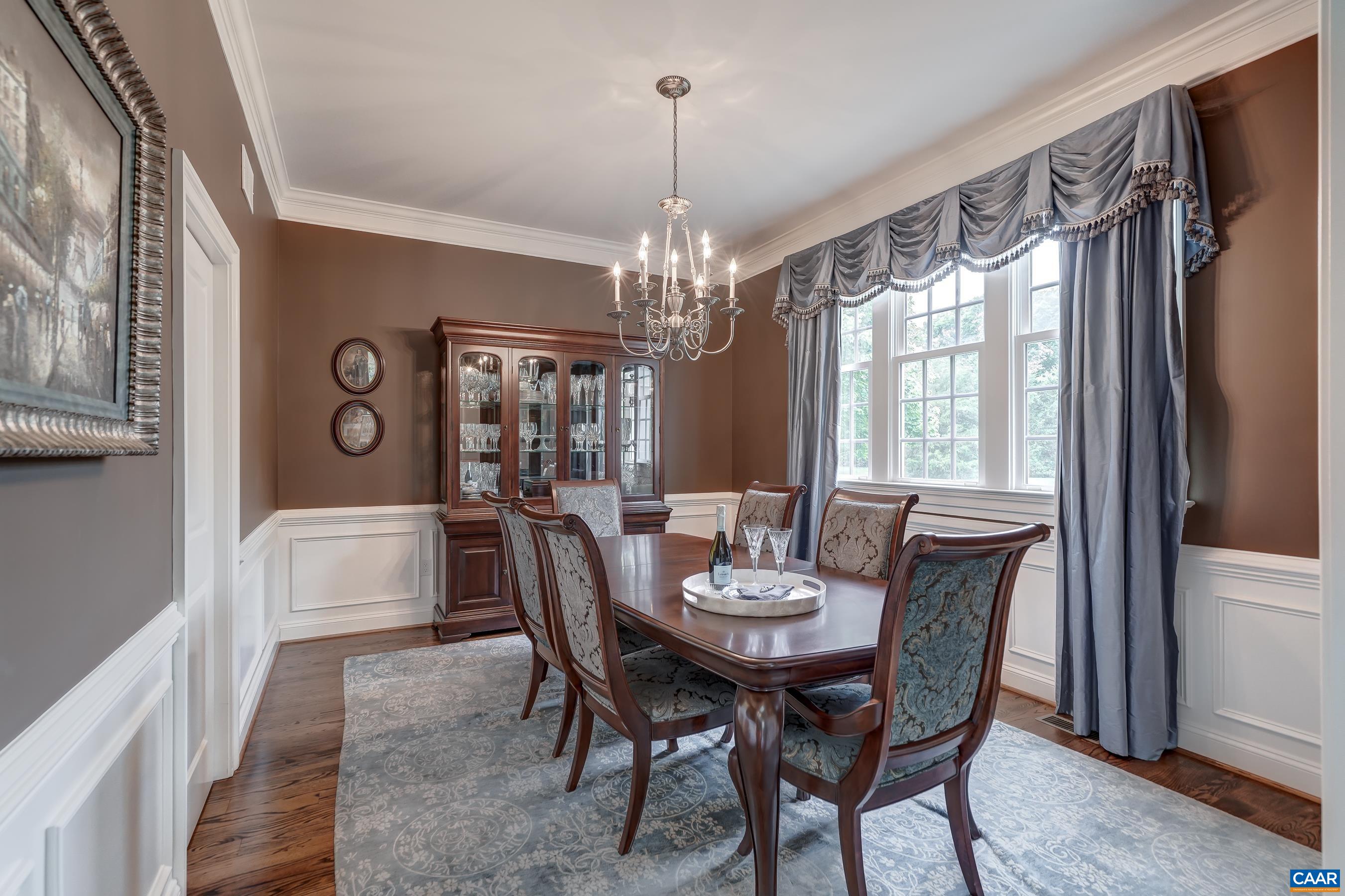 The grand dining room features beautiful wainscoting details and a swinging door to the butlers pantry.