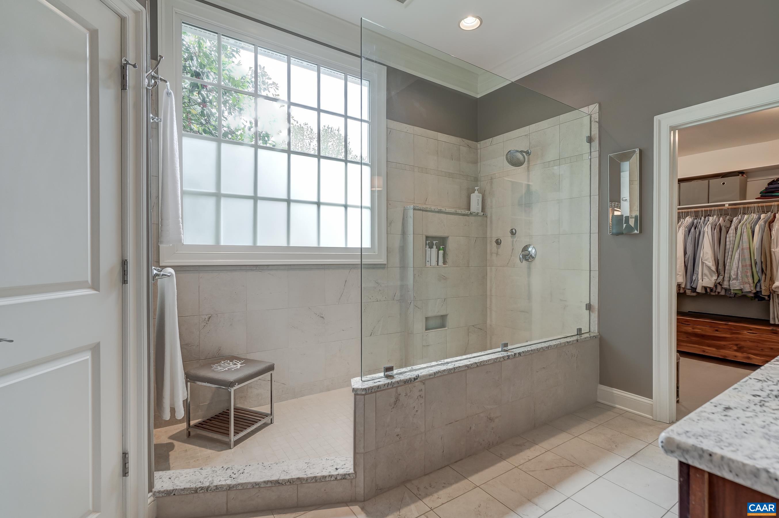 Renovated spa-like ensuite bathroom features a walk-in shower, two separate vanities and a heated tile floor.