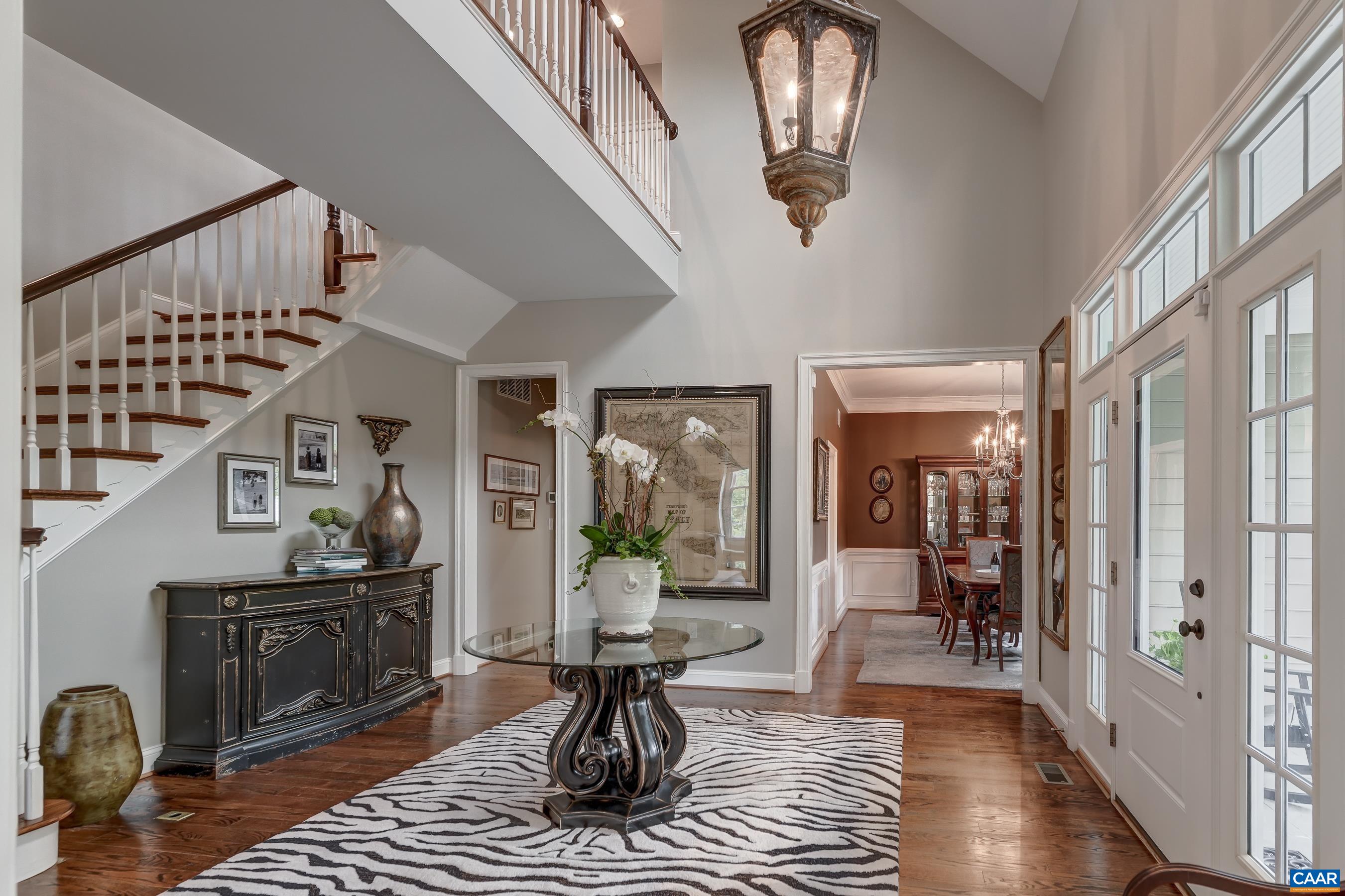 Grand foyer with central staircase is flanked by formal living and dining rooms.