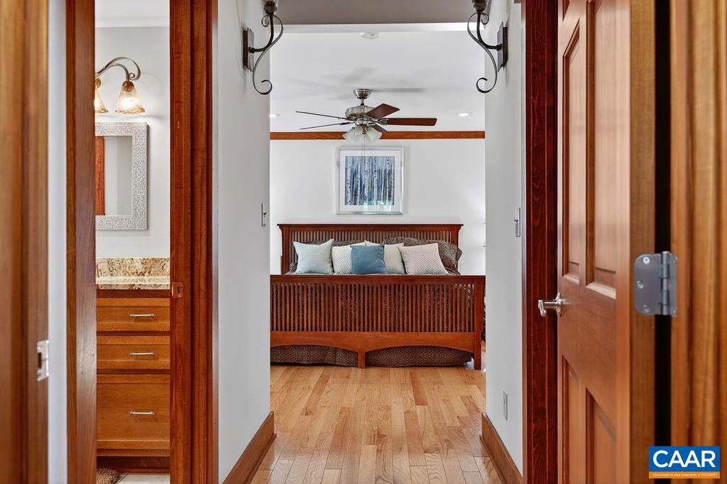 A beautiful main-level primary suite features a spacious bedroom, an impressive walk-in closet, and a large, beautifully appointed bathroom.