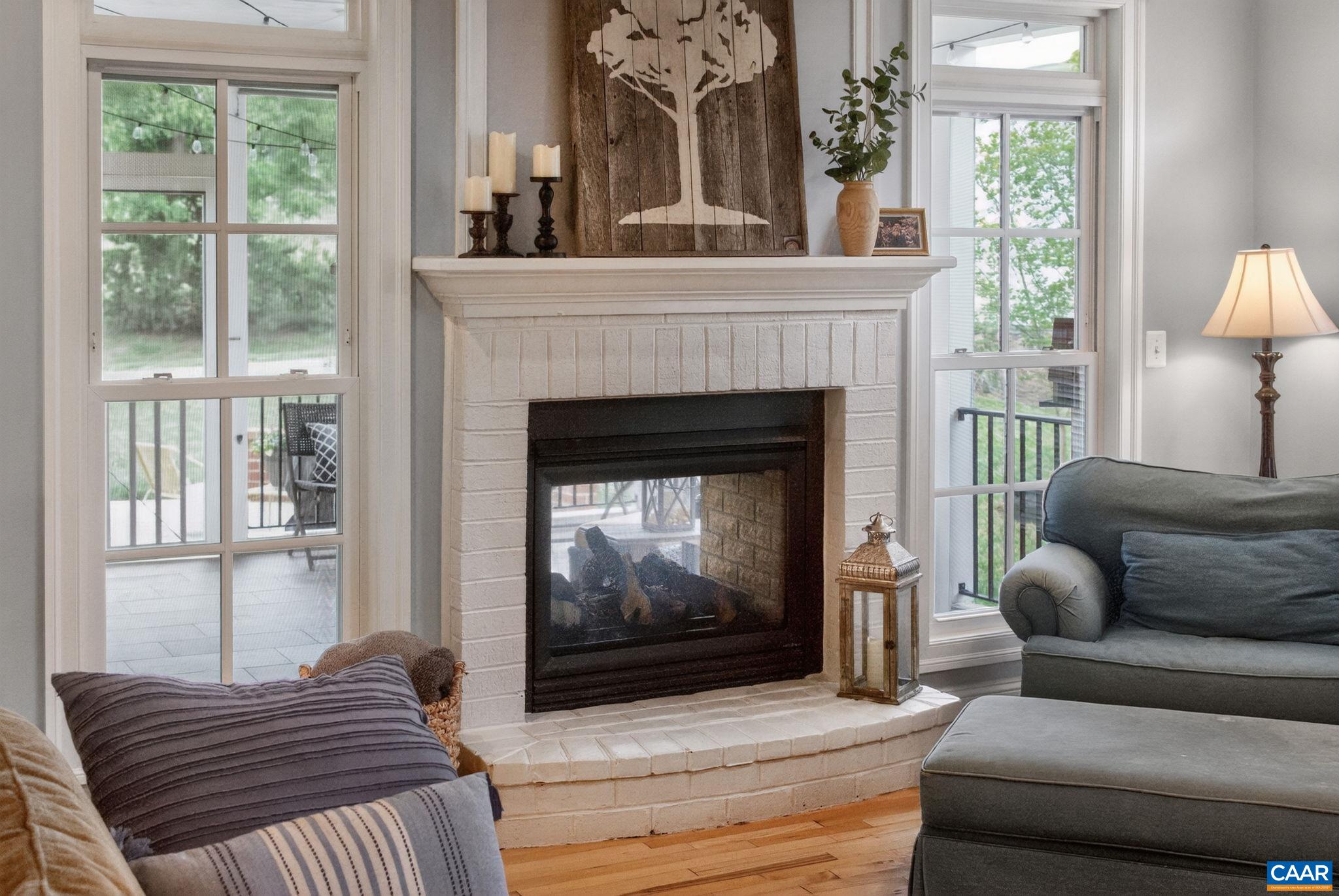 Living room indoor/outdoor gas fireplace is shared with screen porch.