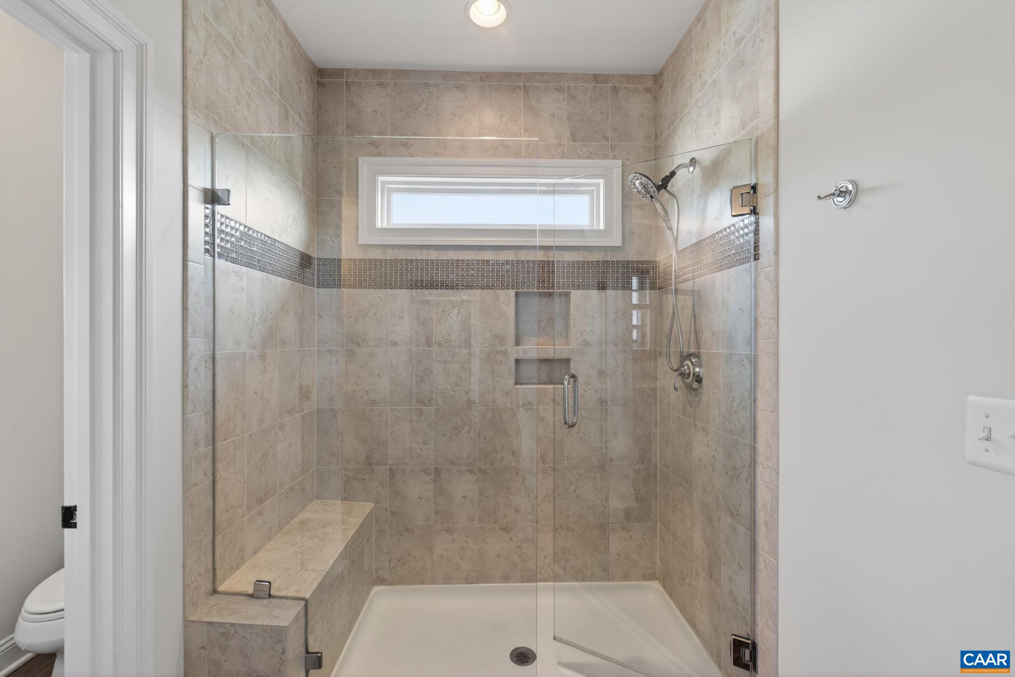 Large tiled primary shower with high window for light!