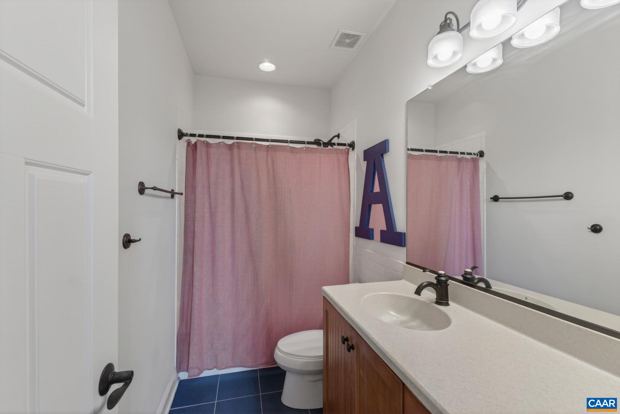 Second level tiled hall bathroom.