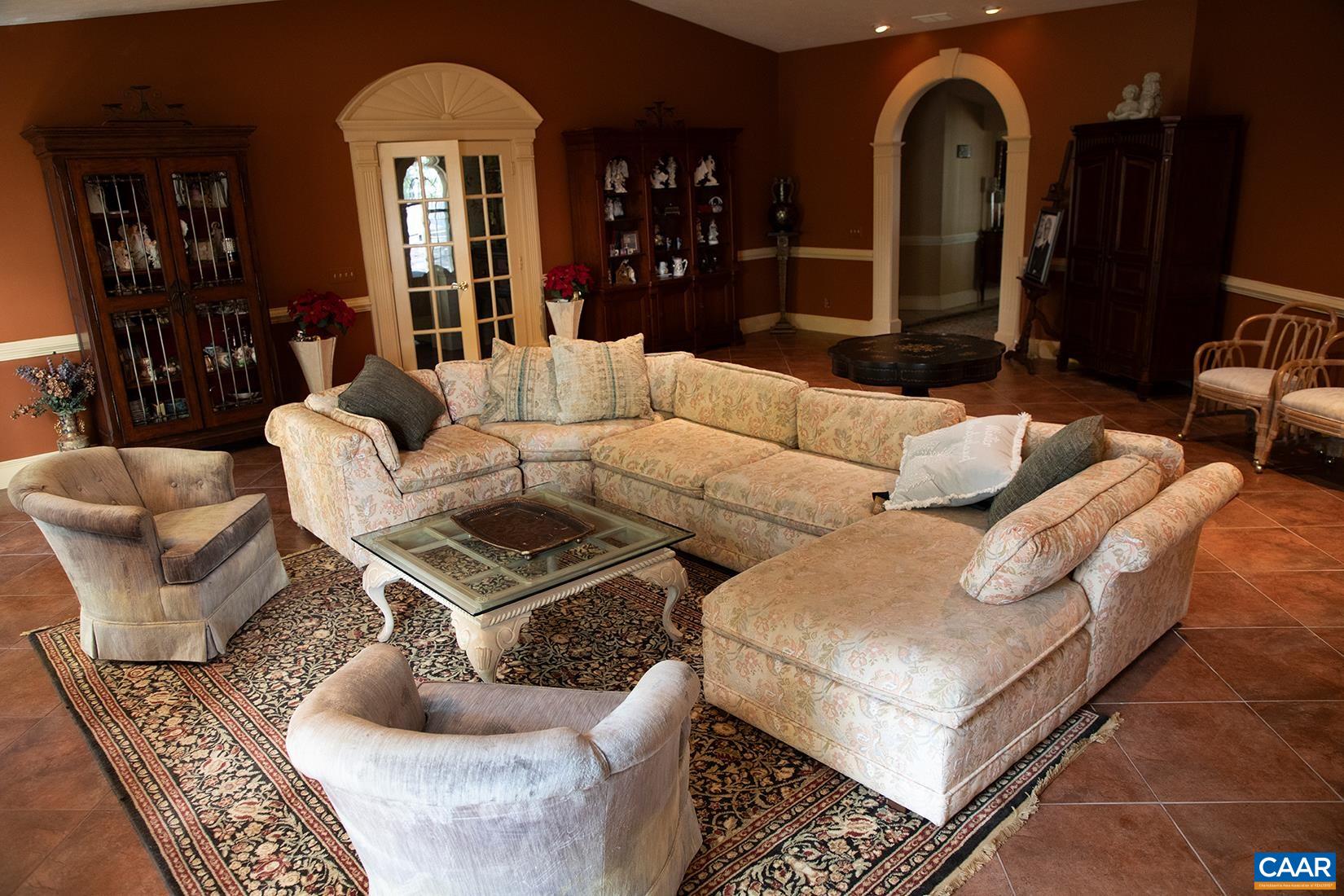 Second level residence includes a large living room with recessed lighting, a gas log fireplace, and custom trim over arch and French doorways.