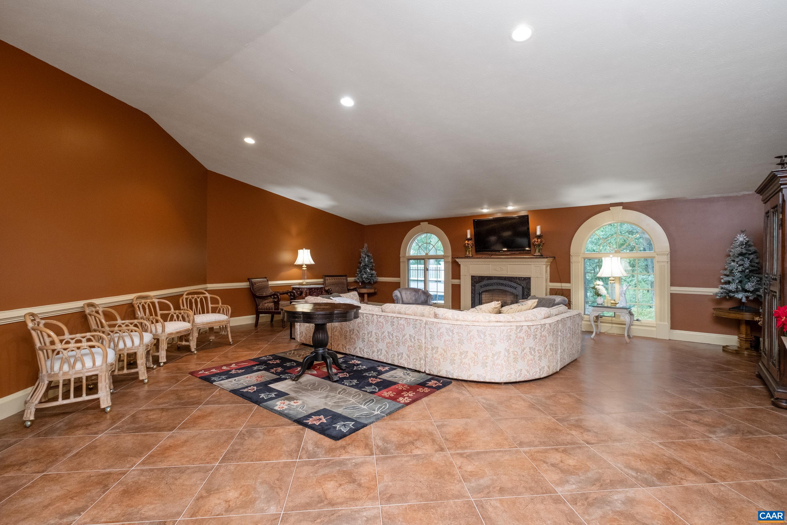 Alternate view of the living room with fireplace in view.  Through the windows, the flattop roof of the addition is in view.