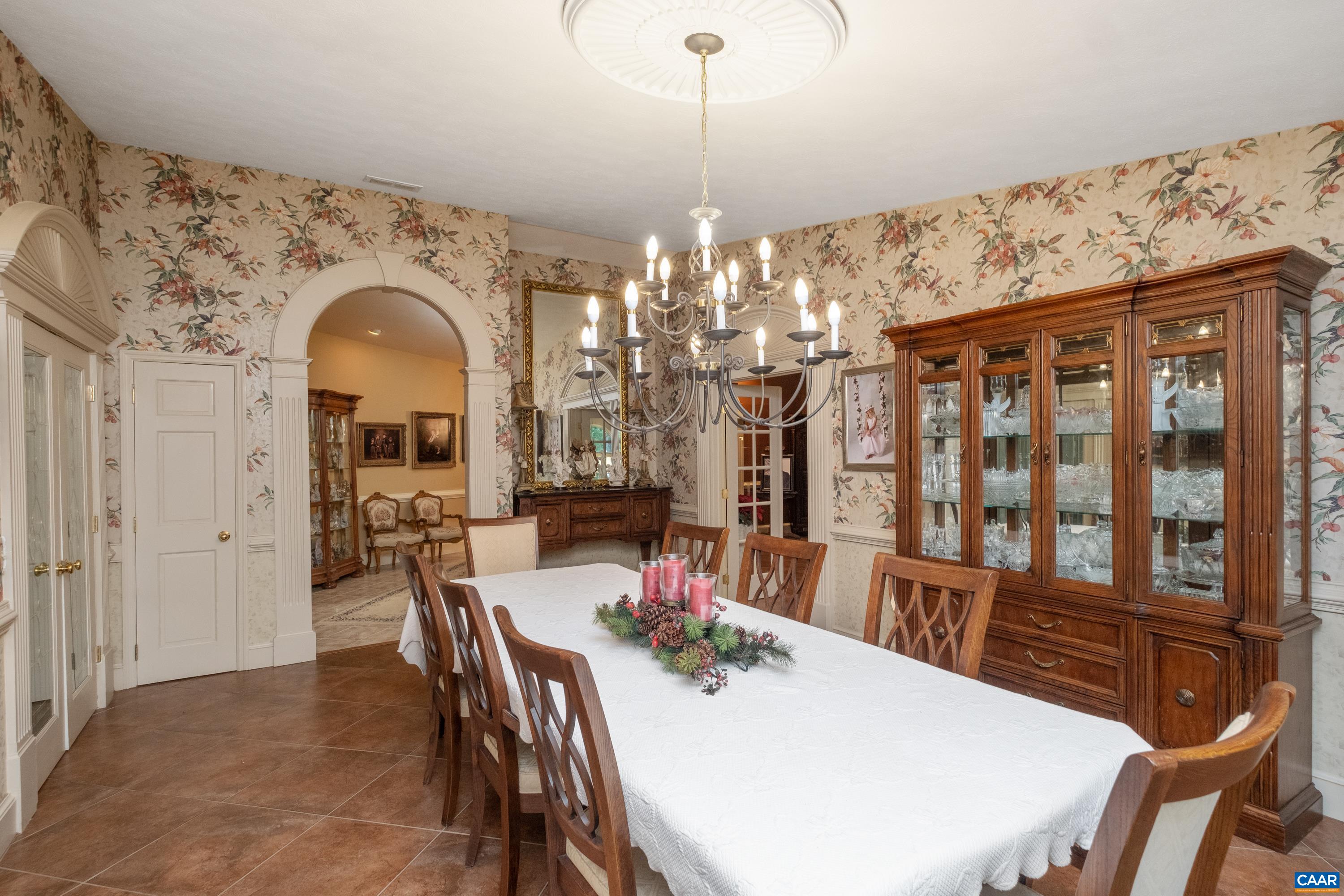 Situated between the living room and the kitchen, find the exquisite dining room with superbly crafted custom trim and arch doorways.  Dining room includes plenty of storage.  Dining room also has a hallway that leads to a half bath and the foyer.