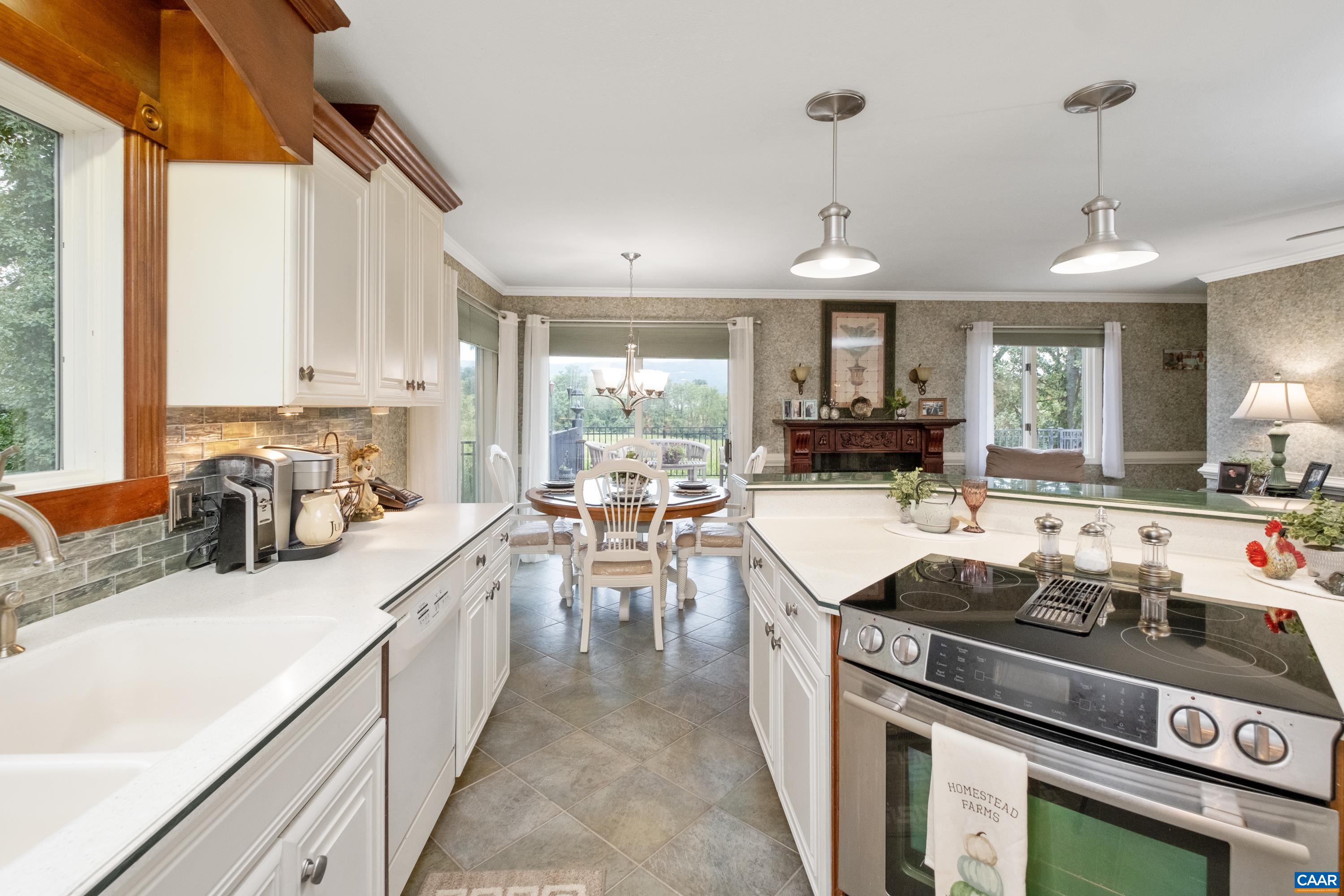 In view are custom cherry cabinetry trim, backsplash, and lovely countertops.