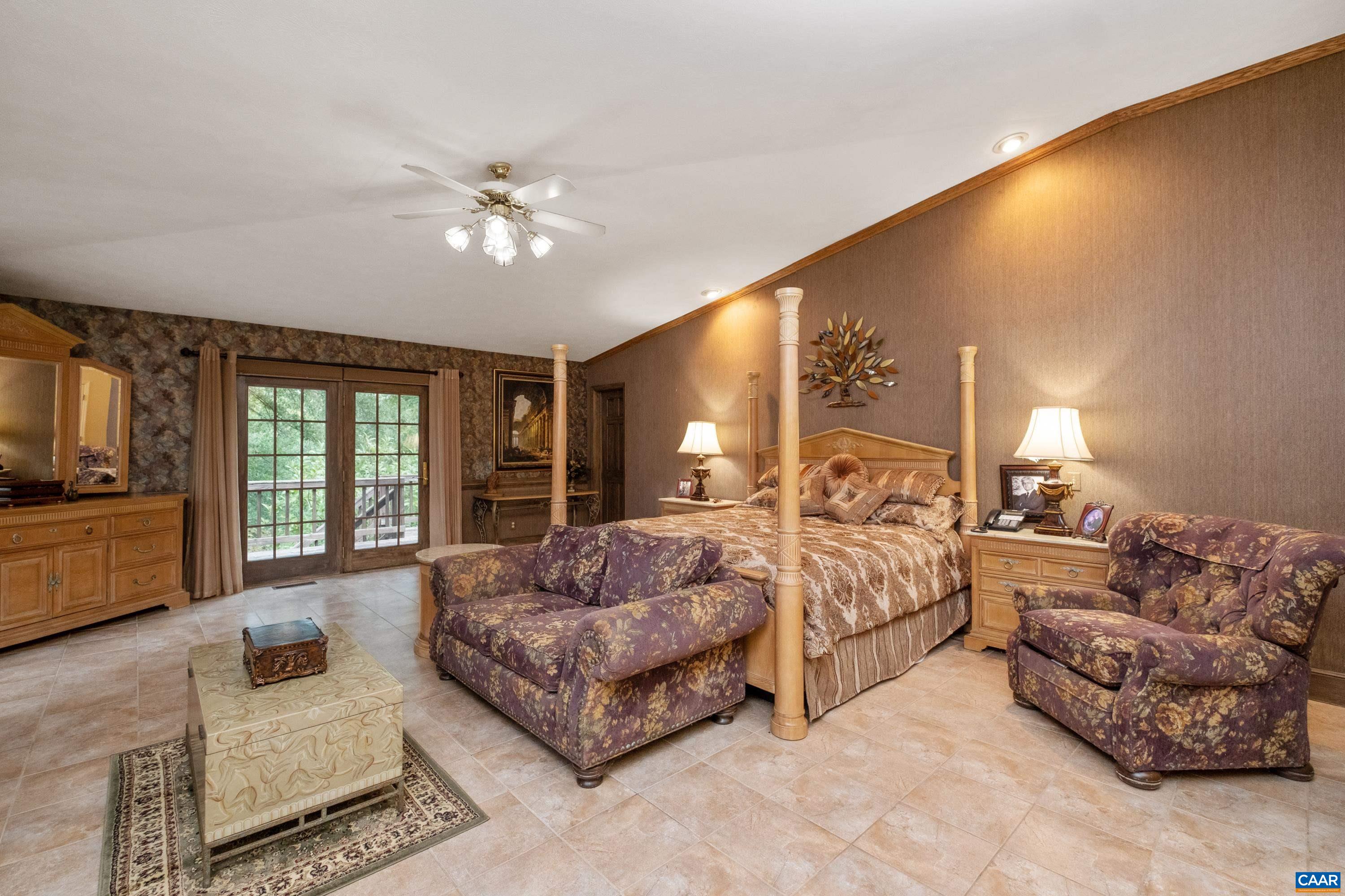 Property features three primary bedrooms with ensuite bathrooms.  In view is the largest primary suite with a private deck.