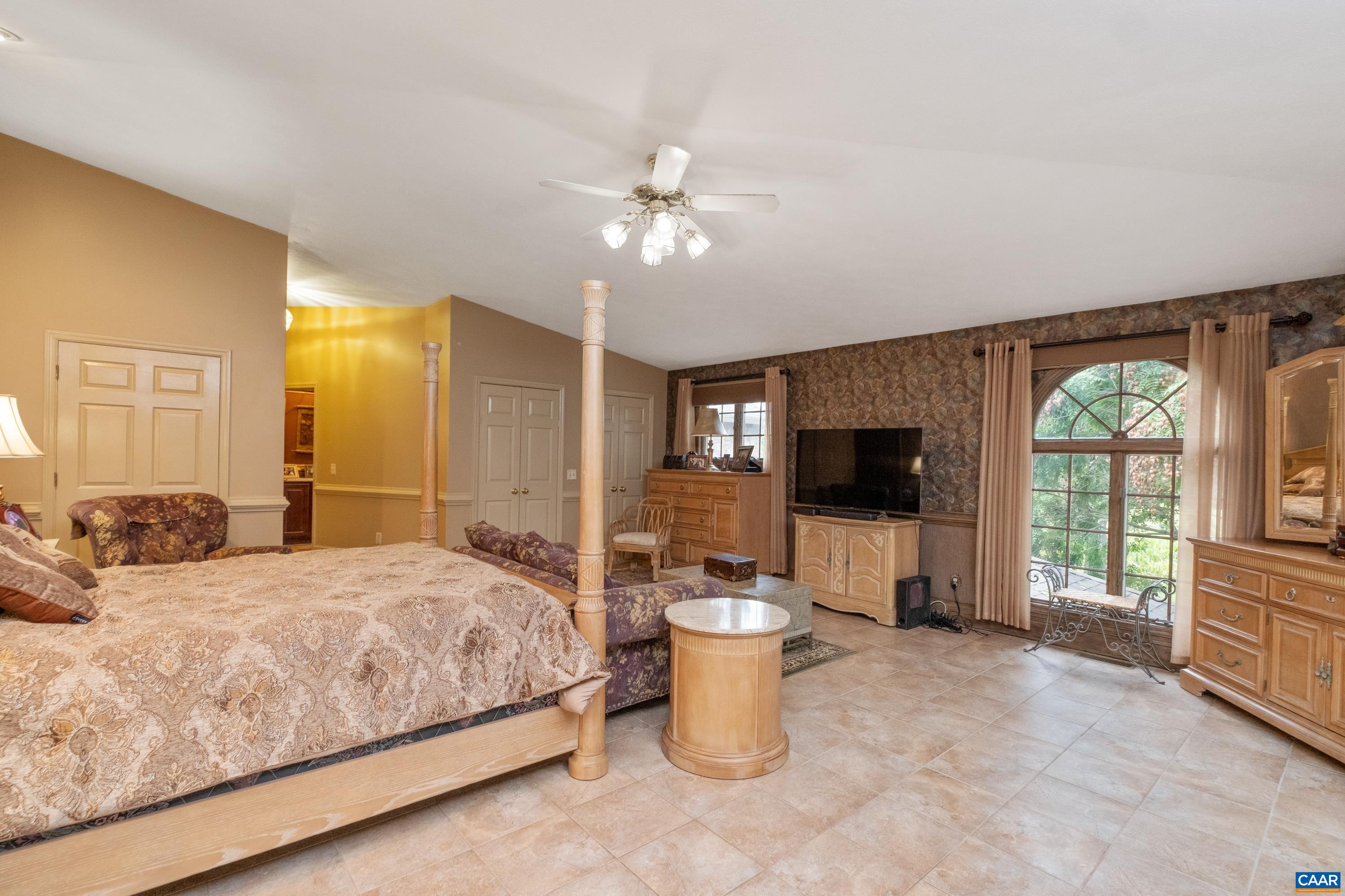 Alternate view of primary suite, looking to the hallway with the primary bathroom.  Plenty of closets are in view, but the primary walk-in closet is located off of the primary bathroom.
