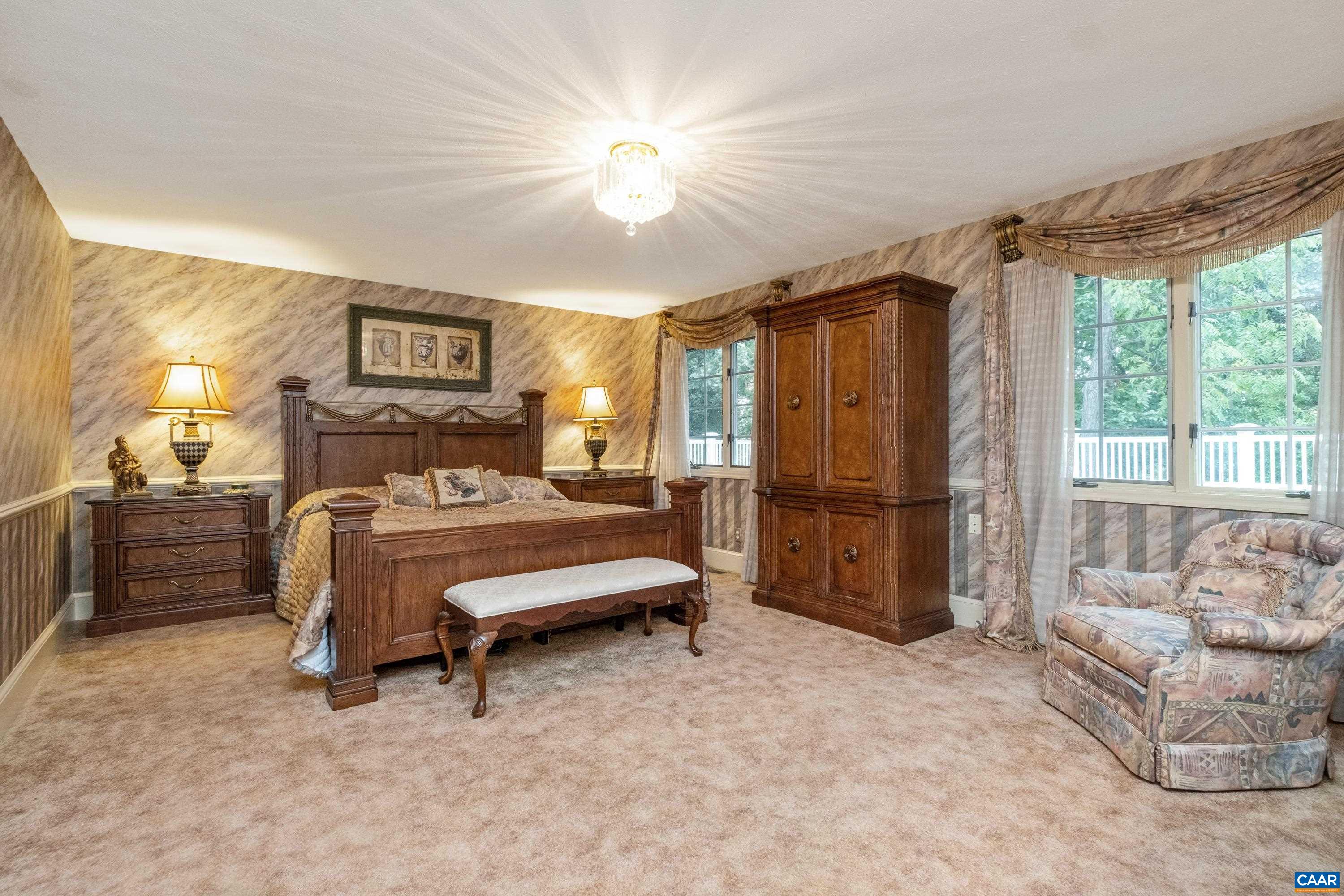 Second primary suite is at the end of the hall and overlooks the flattop roof and lush grounds.