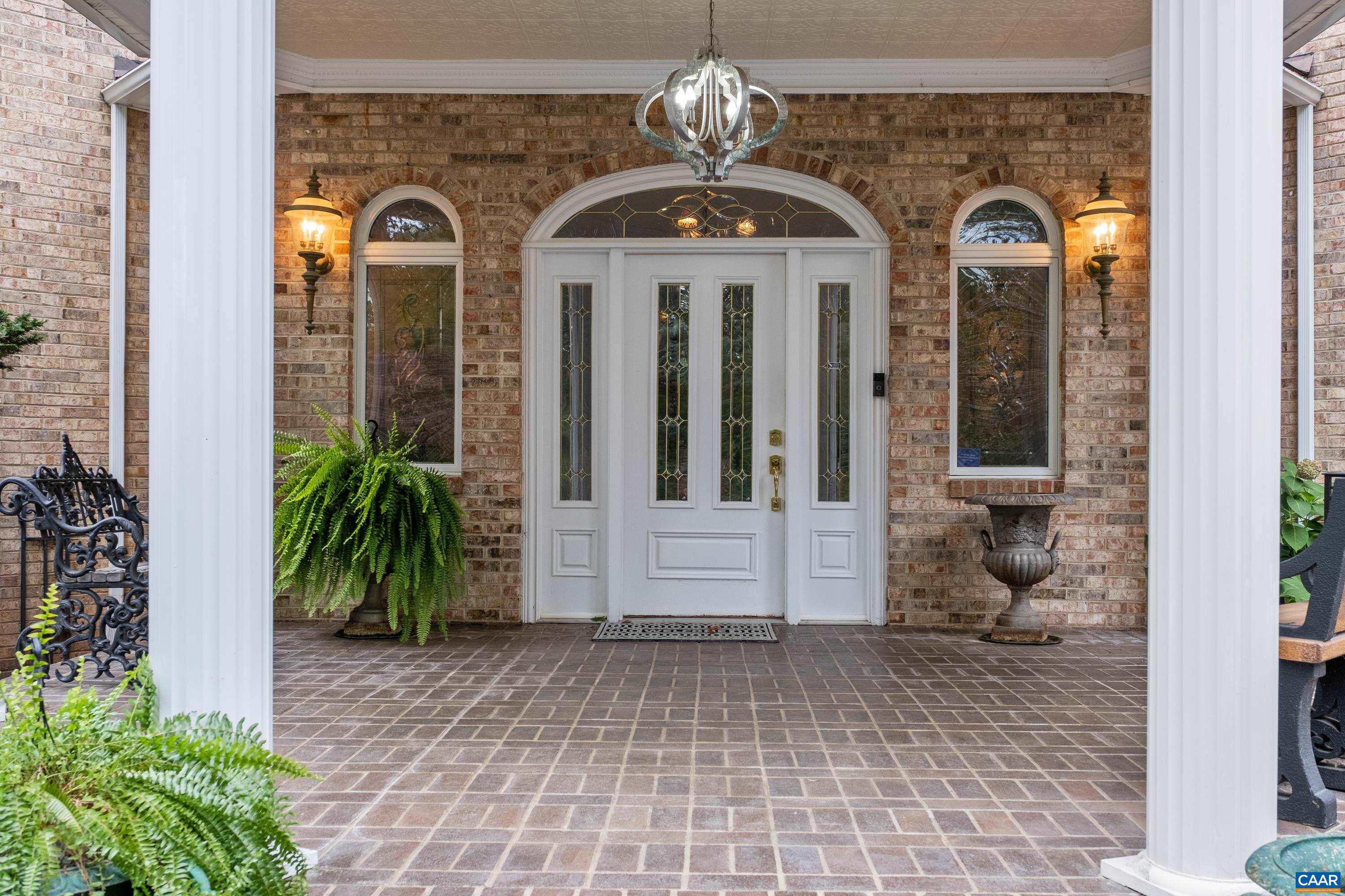 Brick front porch is covered and expansive.