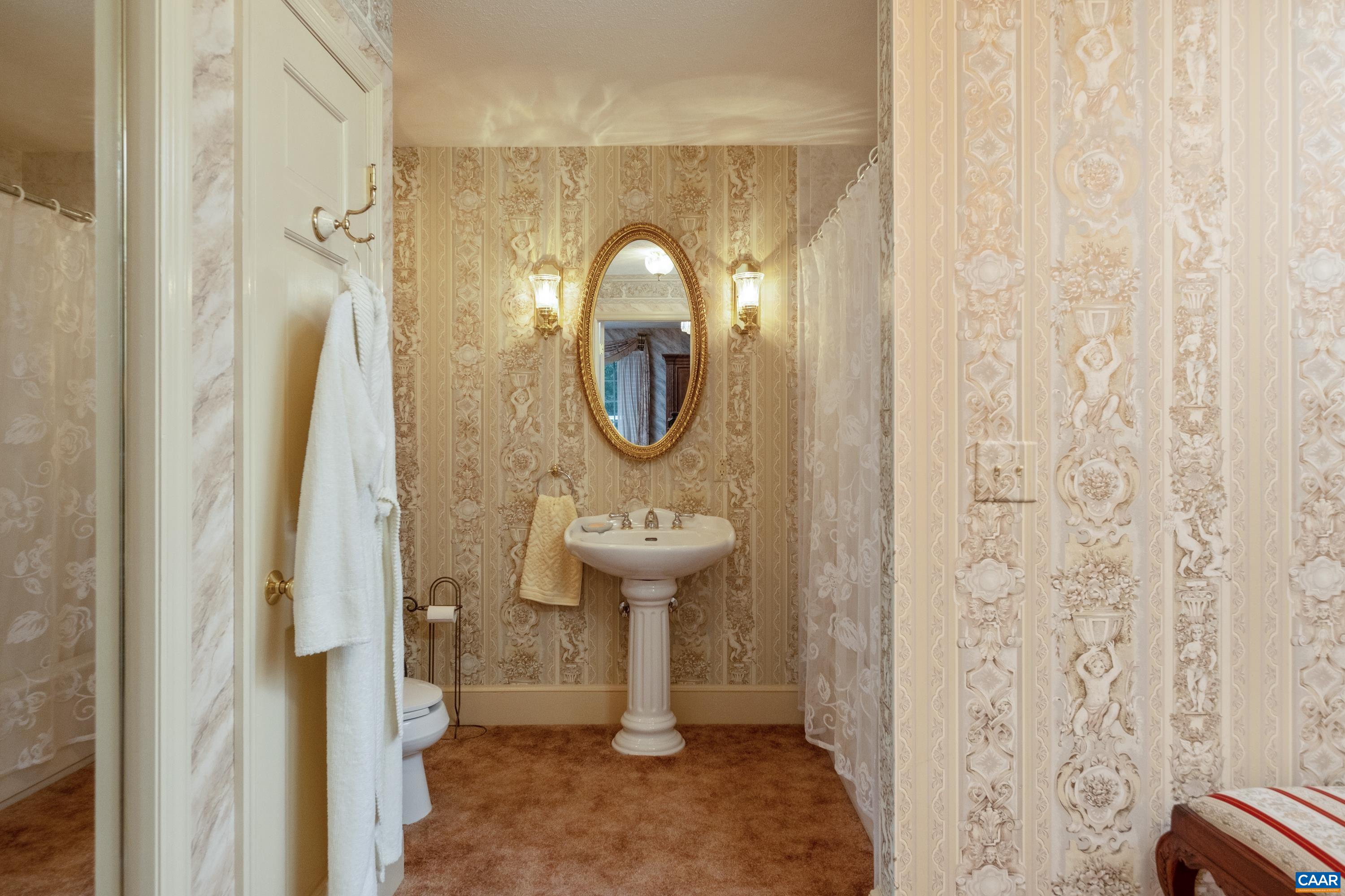 In view is the pedestal sink, shower/tub, closet, with dressing area and closet space to the right of the frame.
