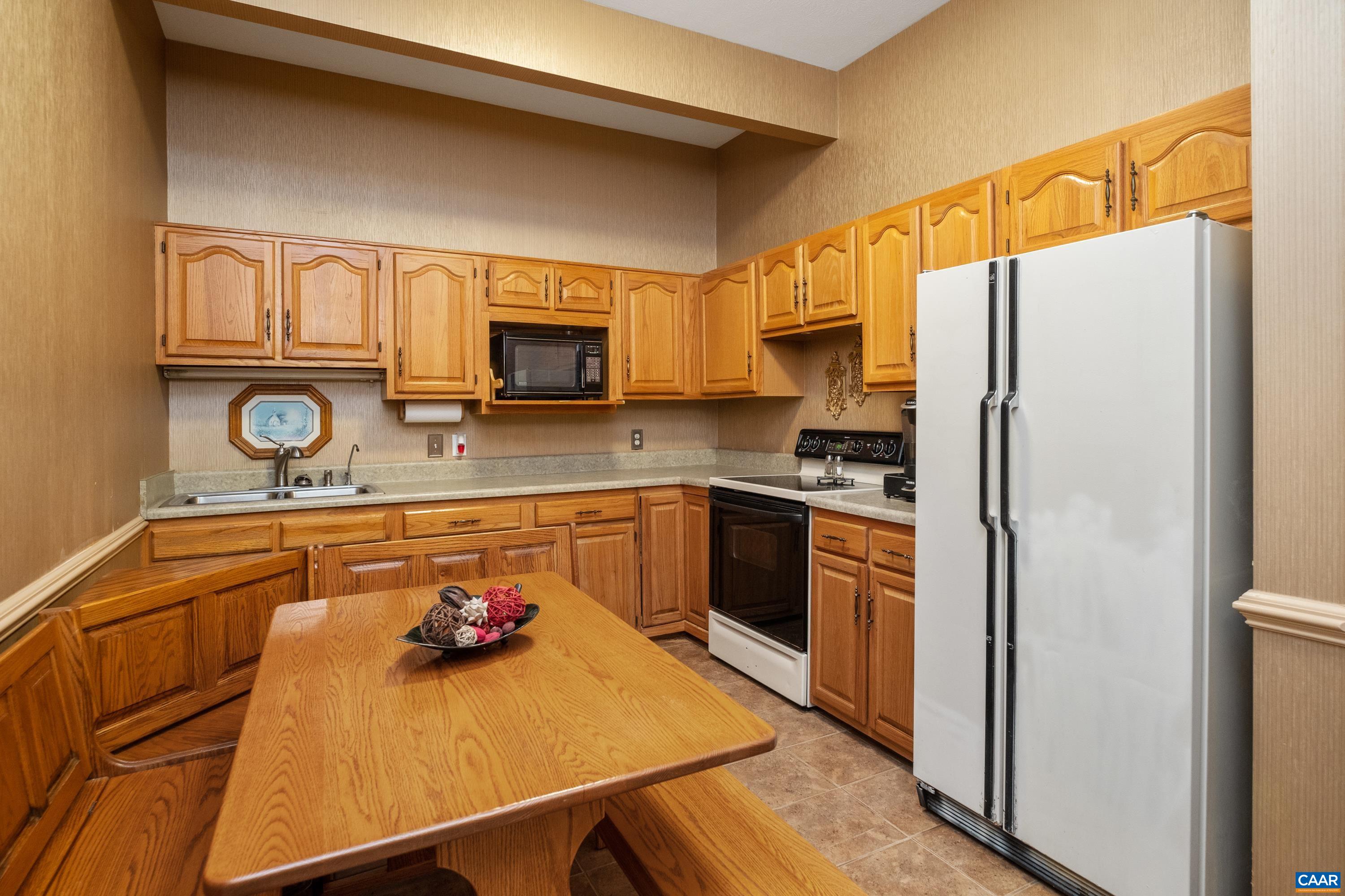 Main level kitchen features oak cabinetry.