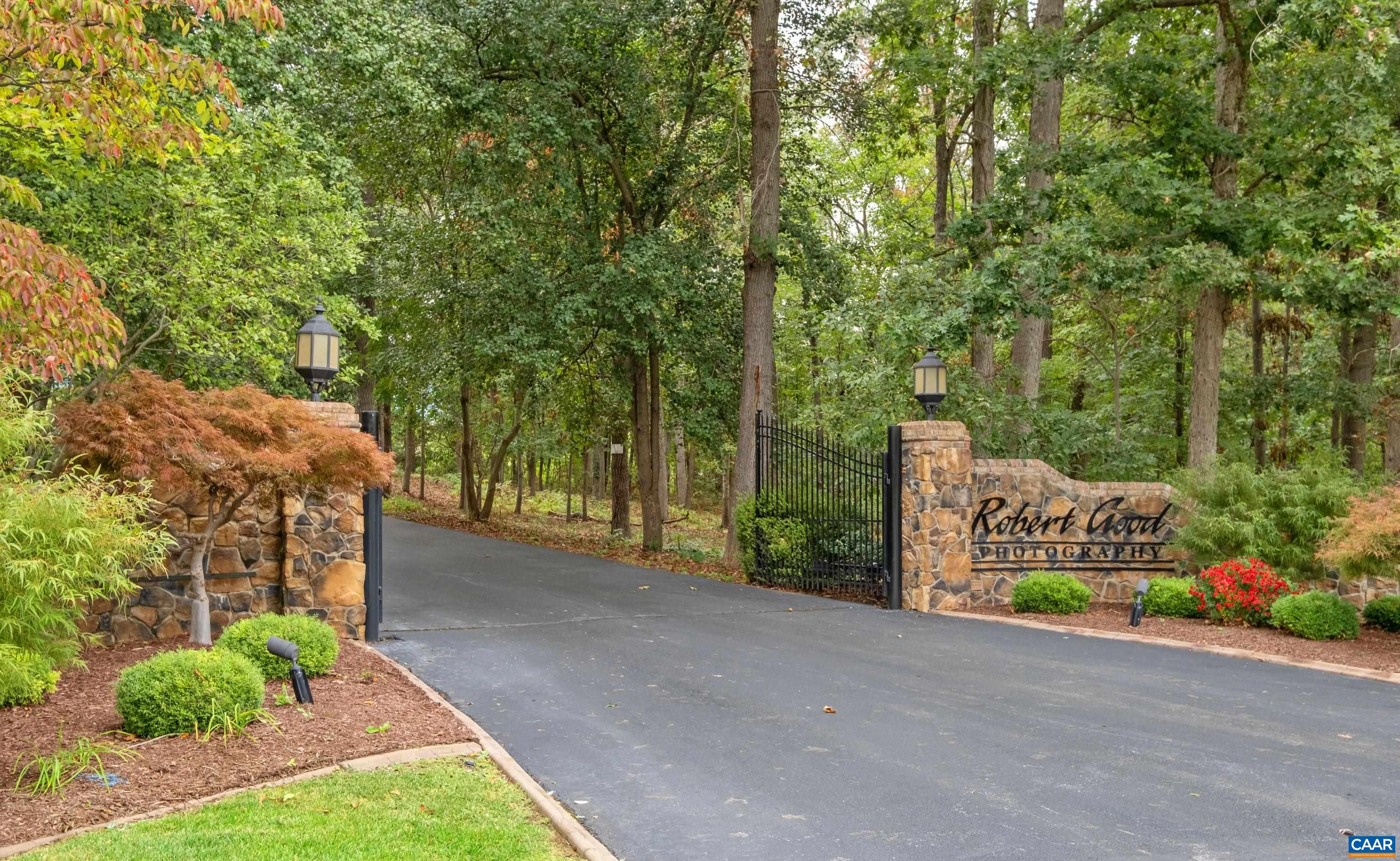Wrought iron gates with stone pillars and lights at the entrance of the property.  Gates are electric.