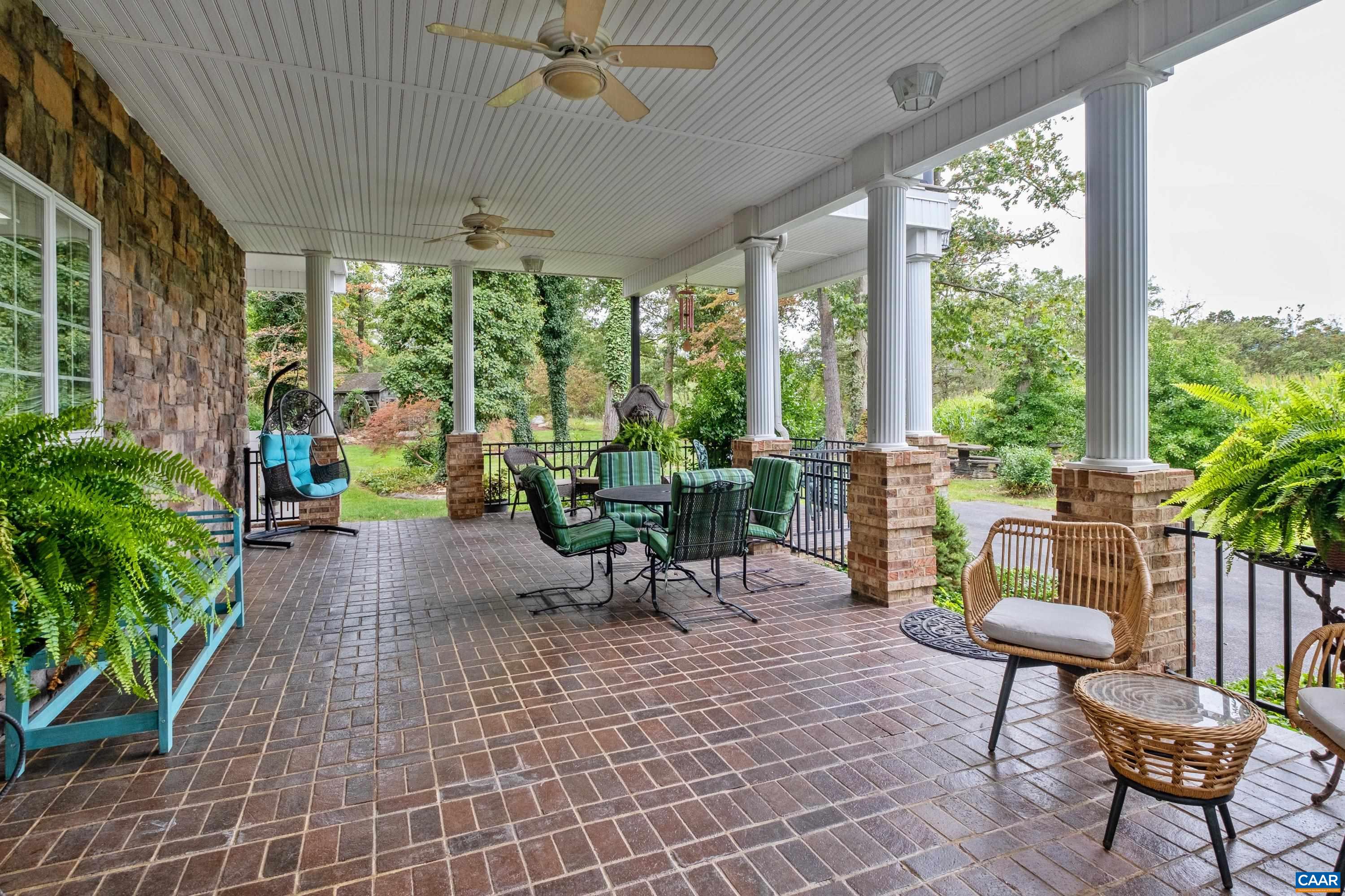 Covered brick patio with wrought iron railings and beautiful mountain views.