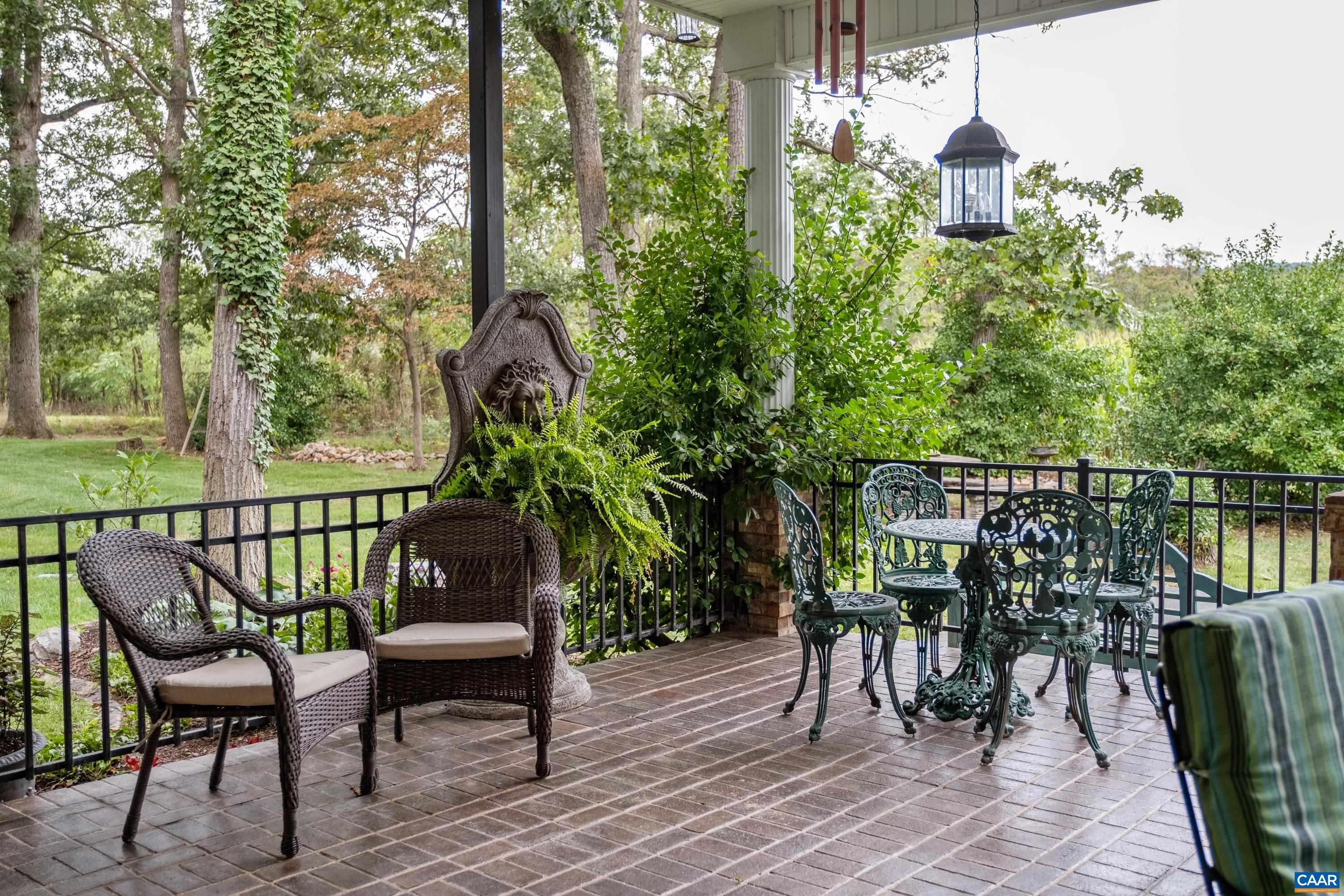 Lush landscaping and plants in view, with wrought iron railings.