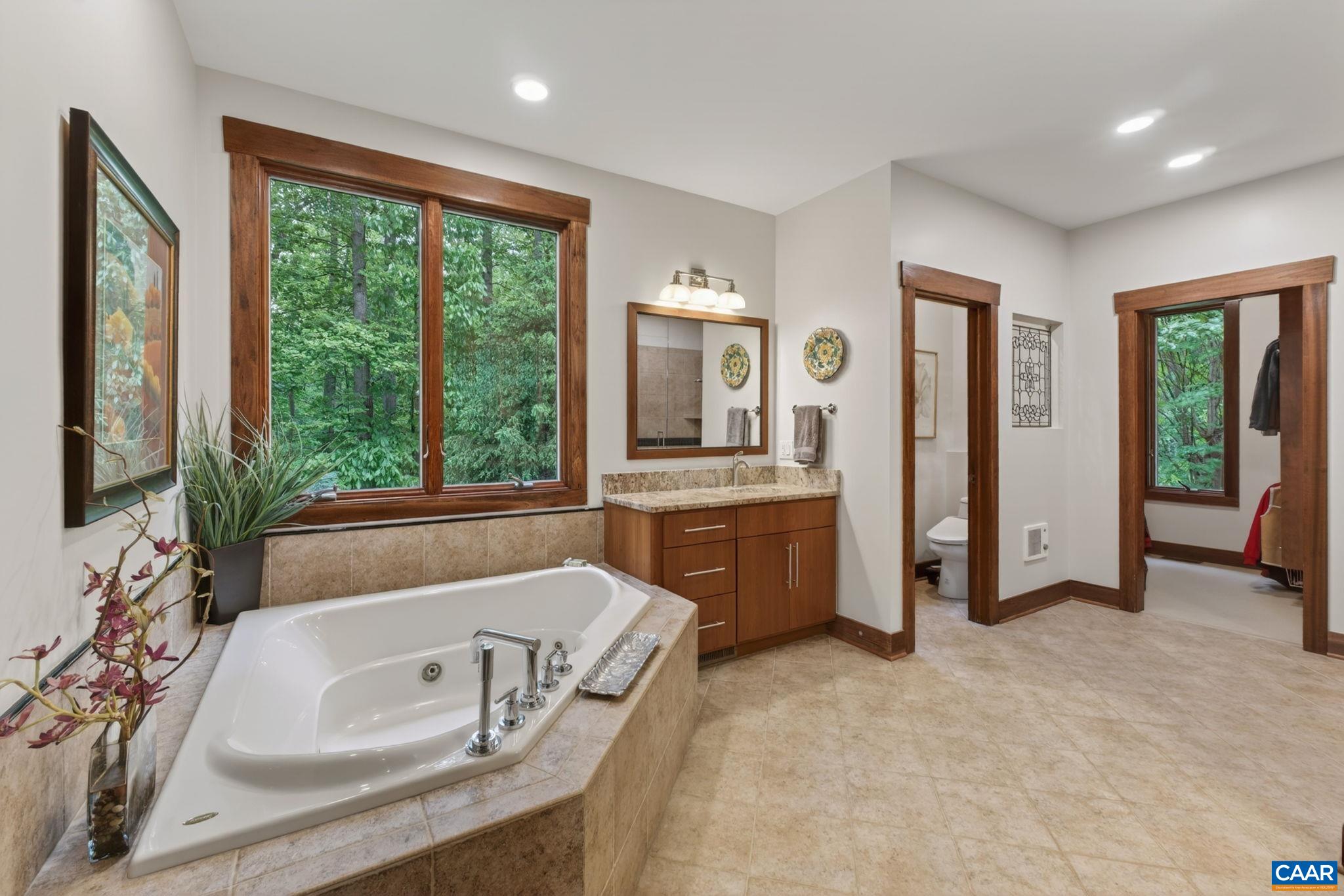 Fully tiled primary bath with separate granite vanities, large soaking tub and oversized shower. Fully tiled primary bath with separate granite vanities, large soaking tub and oversized shower.